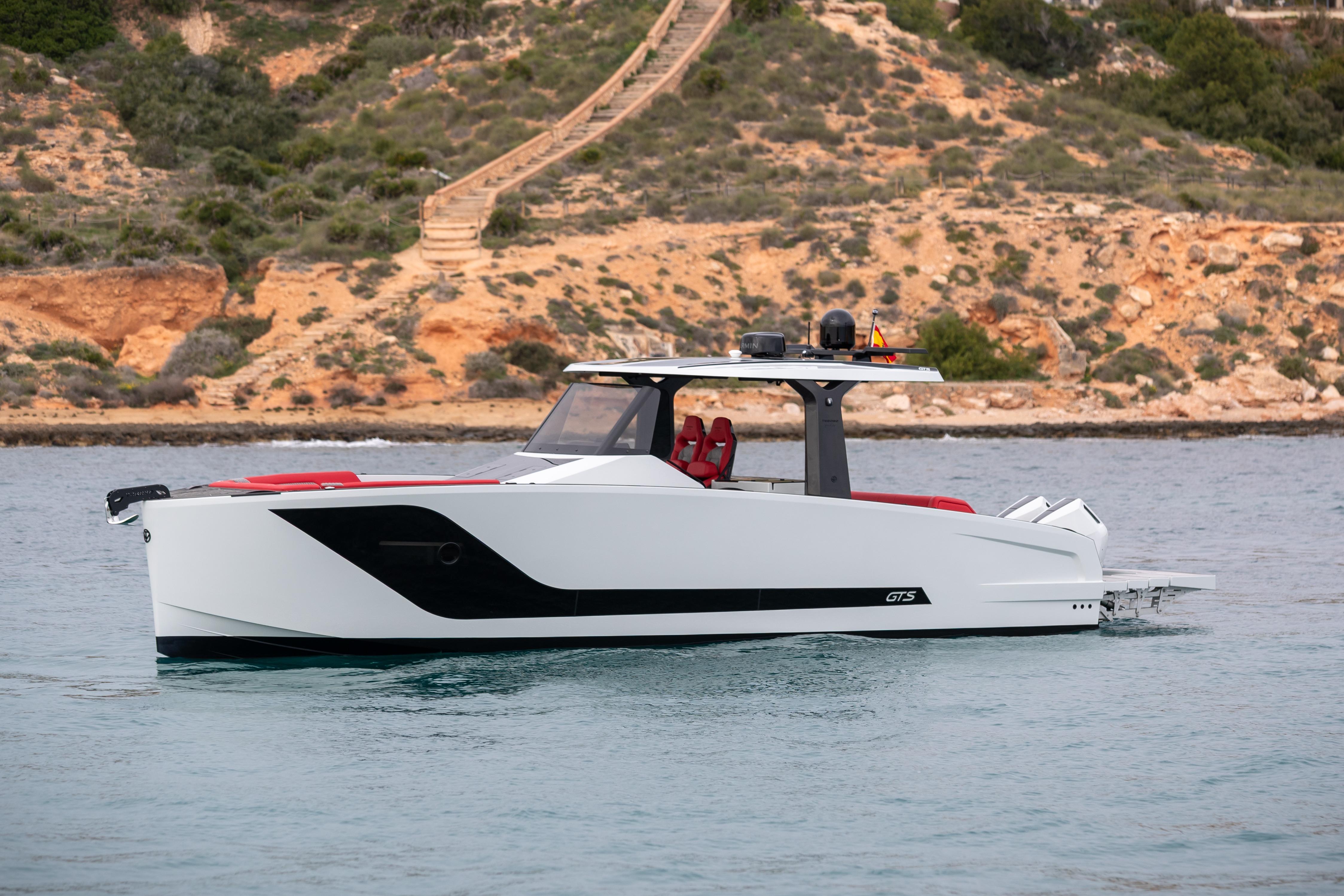 Tesoro 40 GTS 2026 yacht on calm water near rocky coastline.