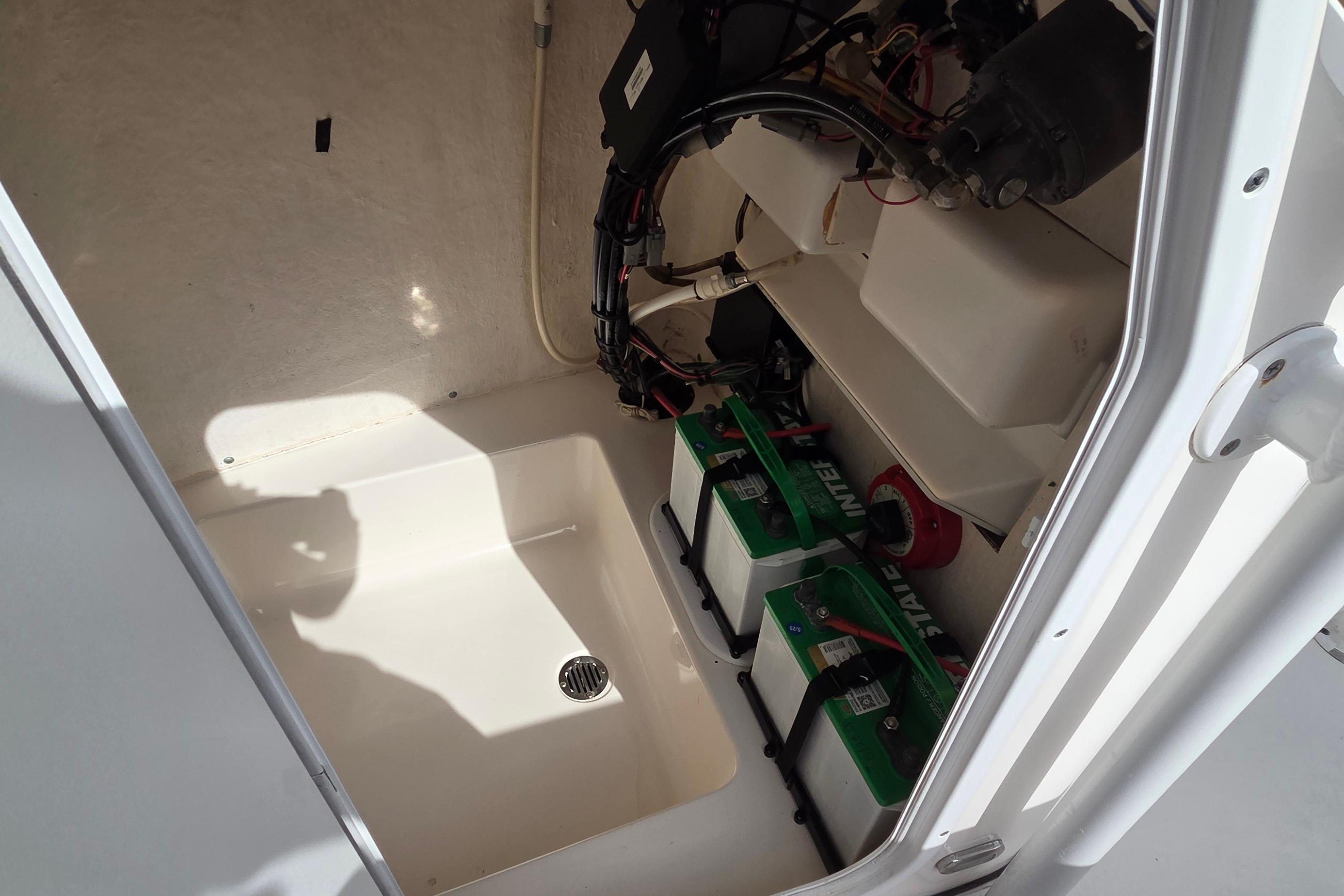 2015 Tidewater 220 LXF boat battery compartment with wiring and drainage.