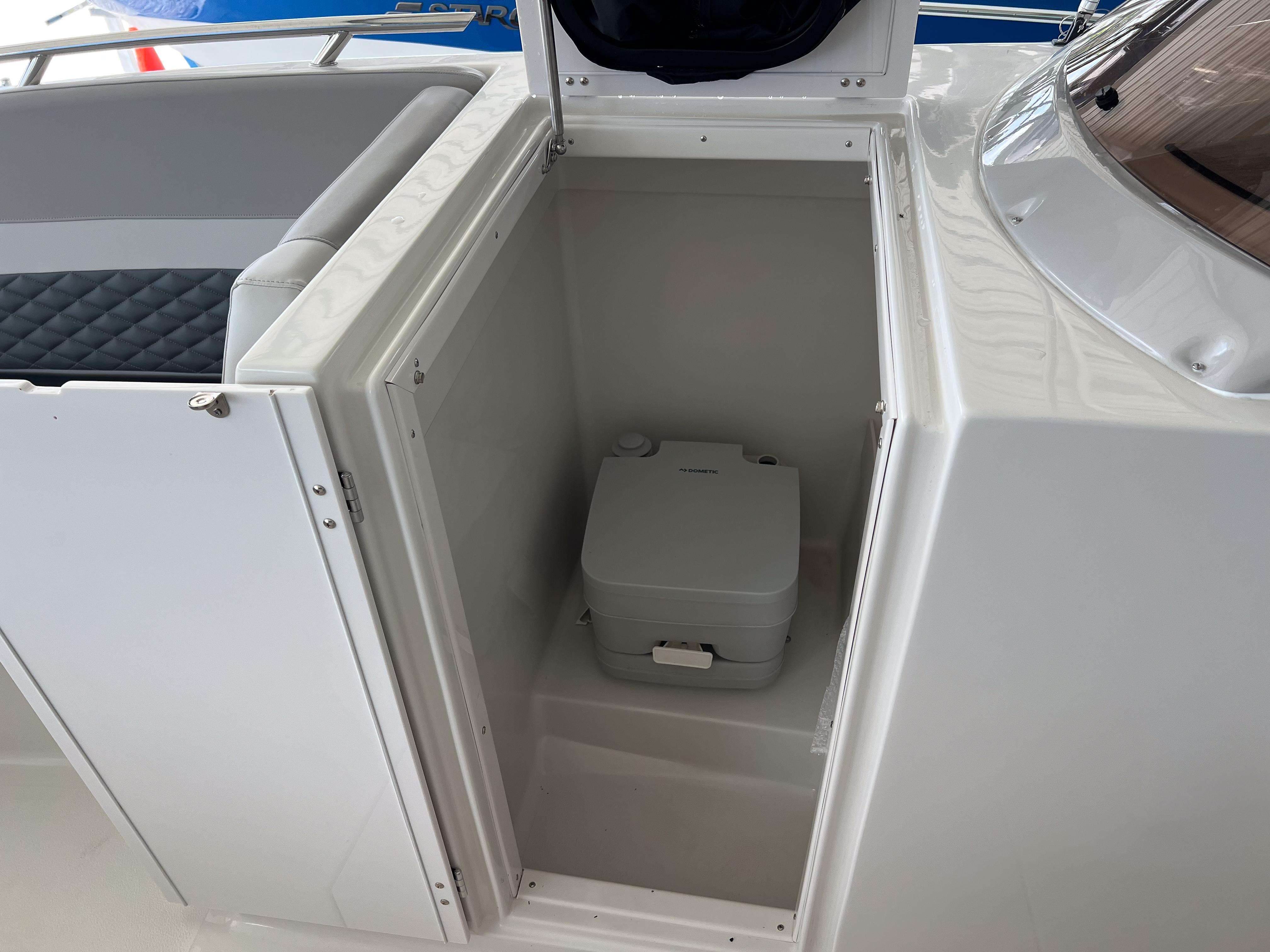 2026 Starcraft SVX 231 OB boat interior with a compact portable toilet.