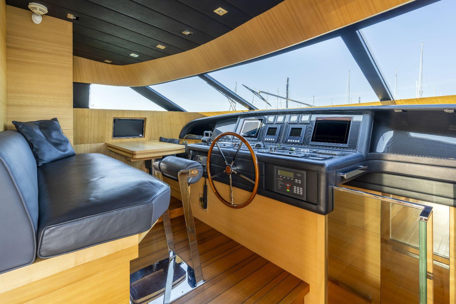 Luxurious 2011 Maiora 27 yacht helm with modern navigation equipment and elegant wood finish.