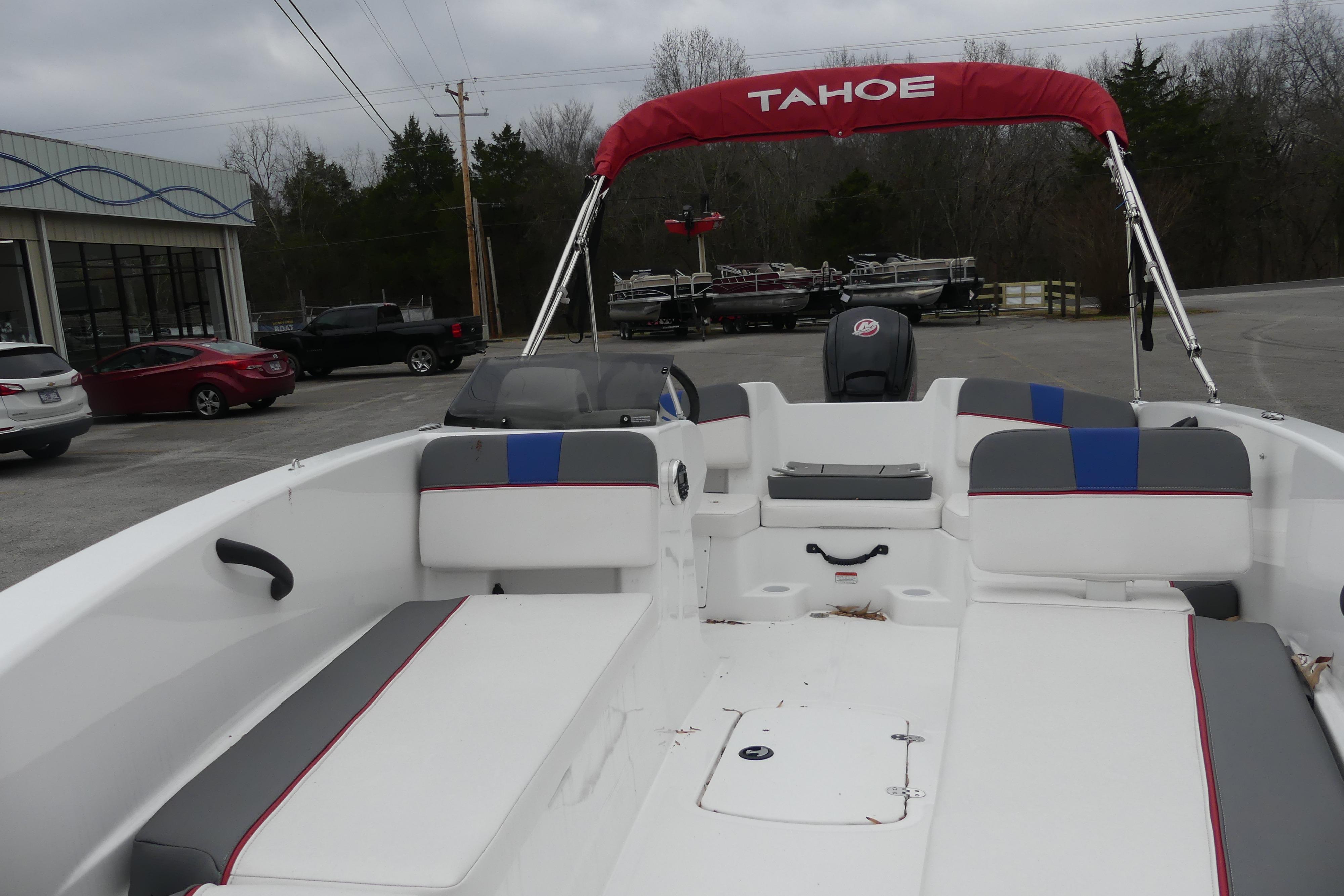 2024 Tahoe T18 boat with red canopy and spacious seating, parked outdoors.