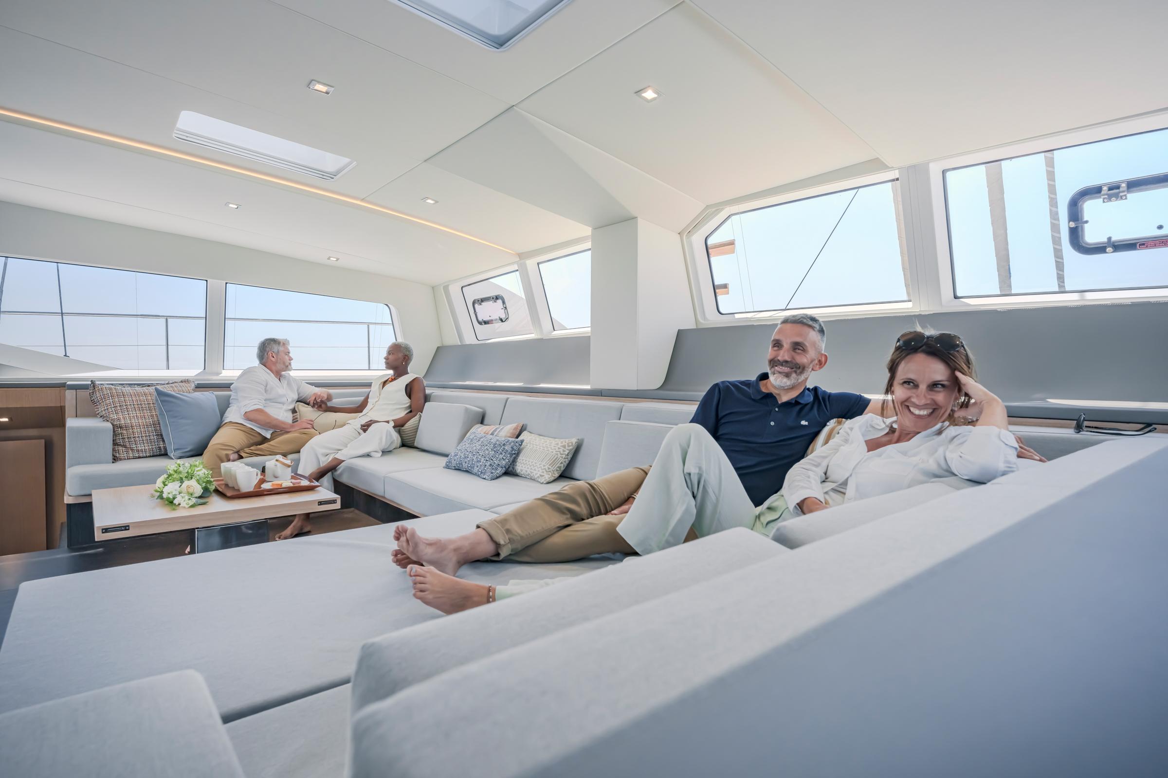 Luxurious interior of 2025 Privilege Signature 650 yacht with relaxed passengers.