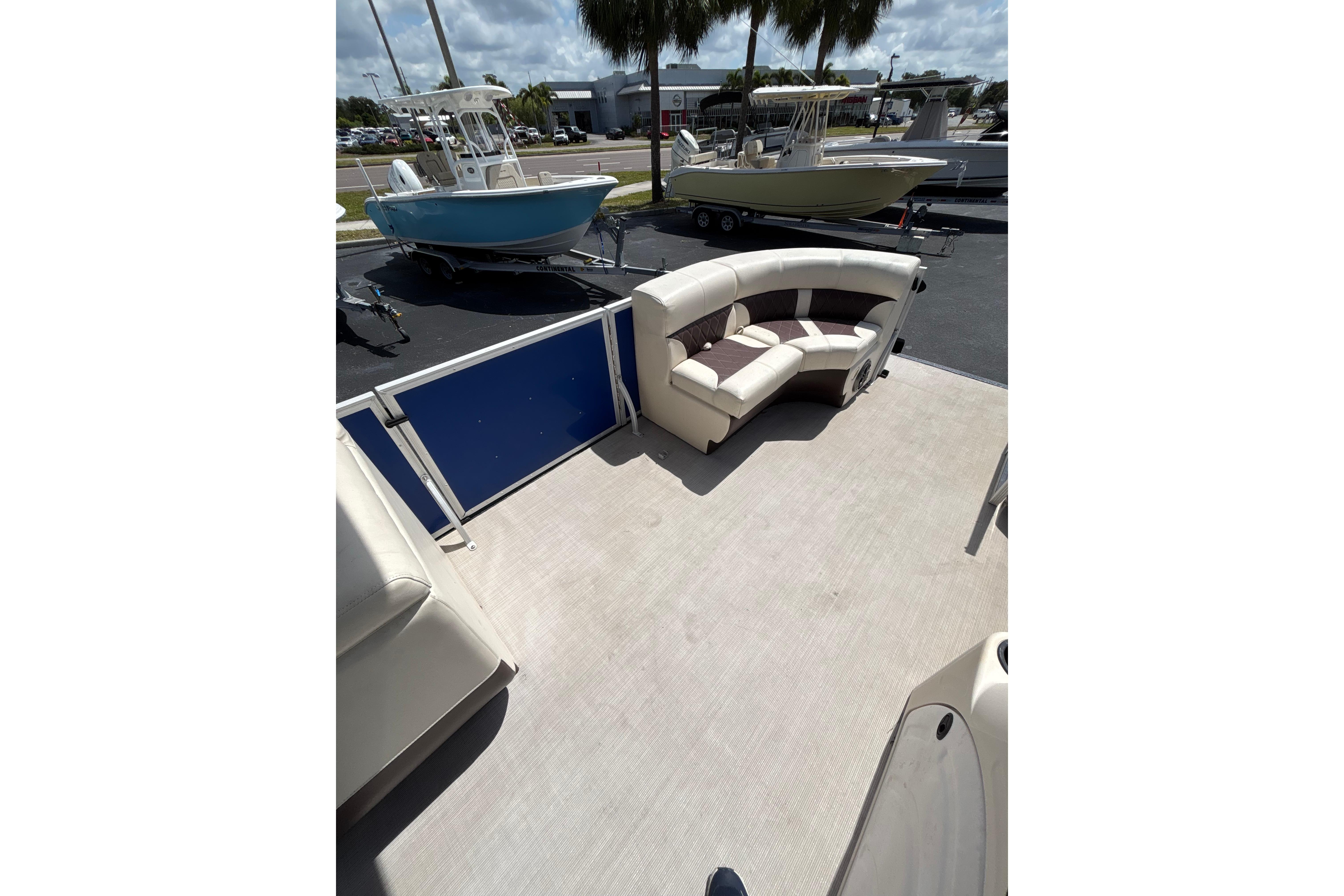 Interior of 2022 Lexington 323 boat with seating, parked near other boats.