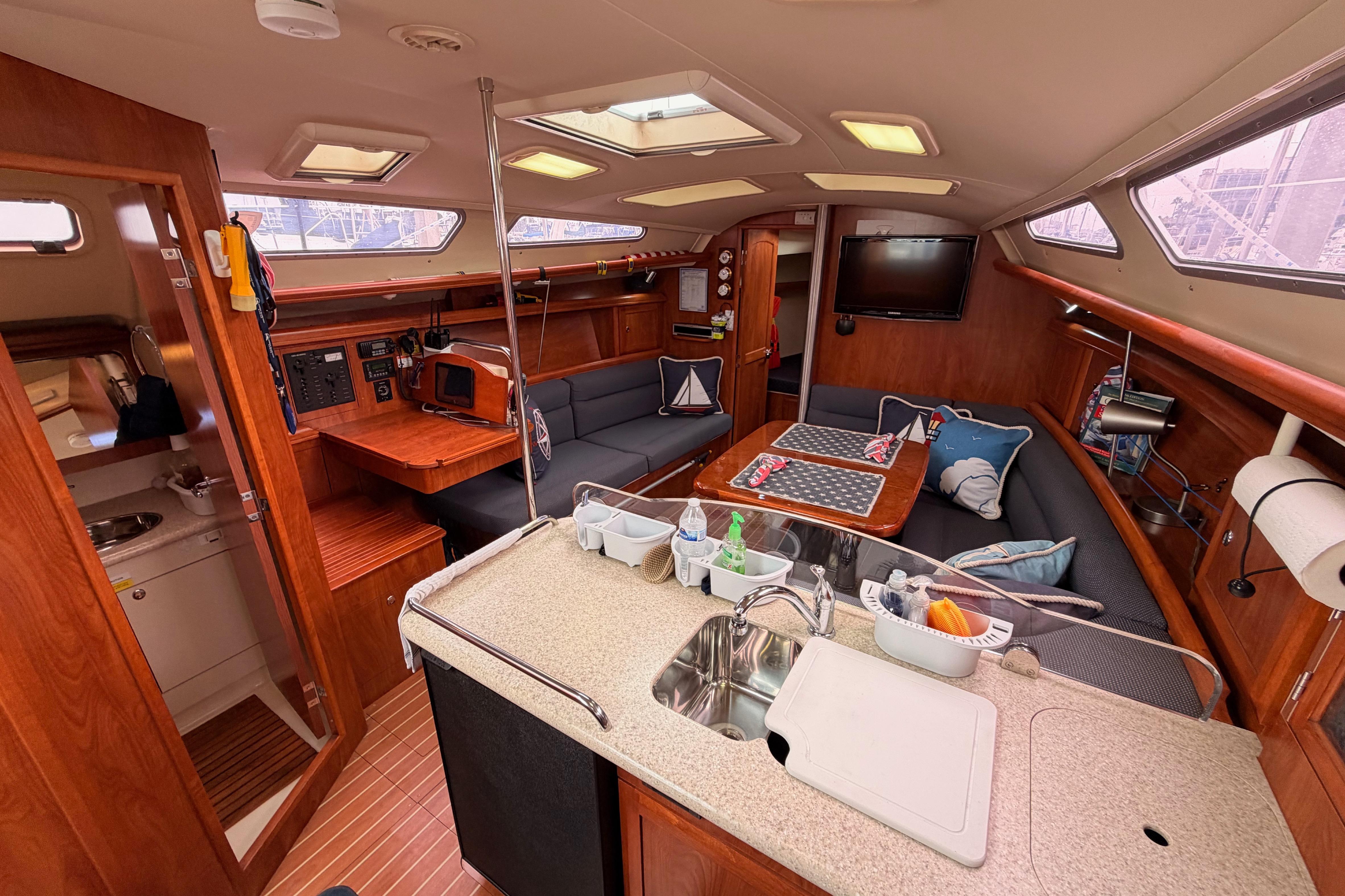 Interior of 2009 Hunter 38 sailboat with cozy seating, kitchenette, and modern amenities.