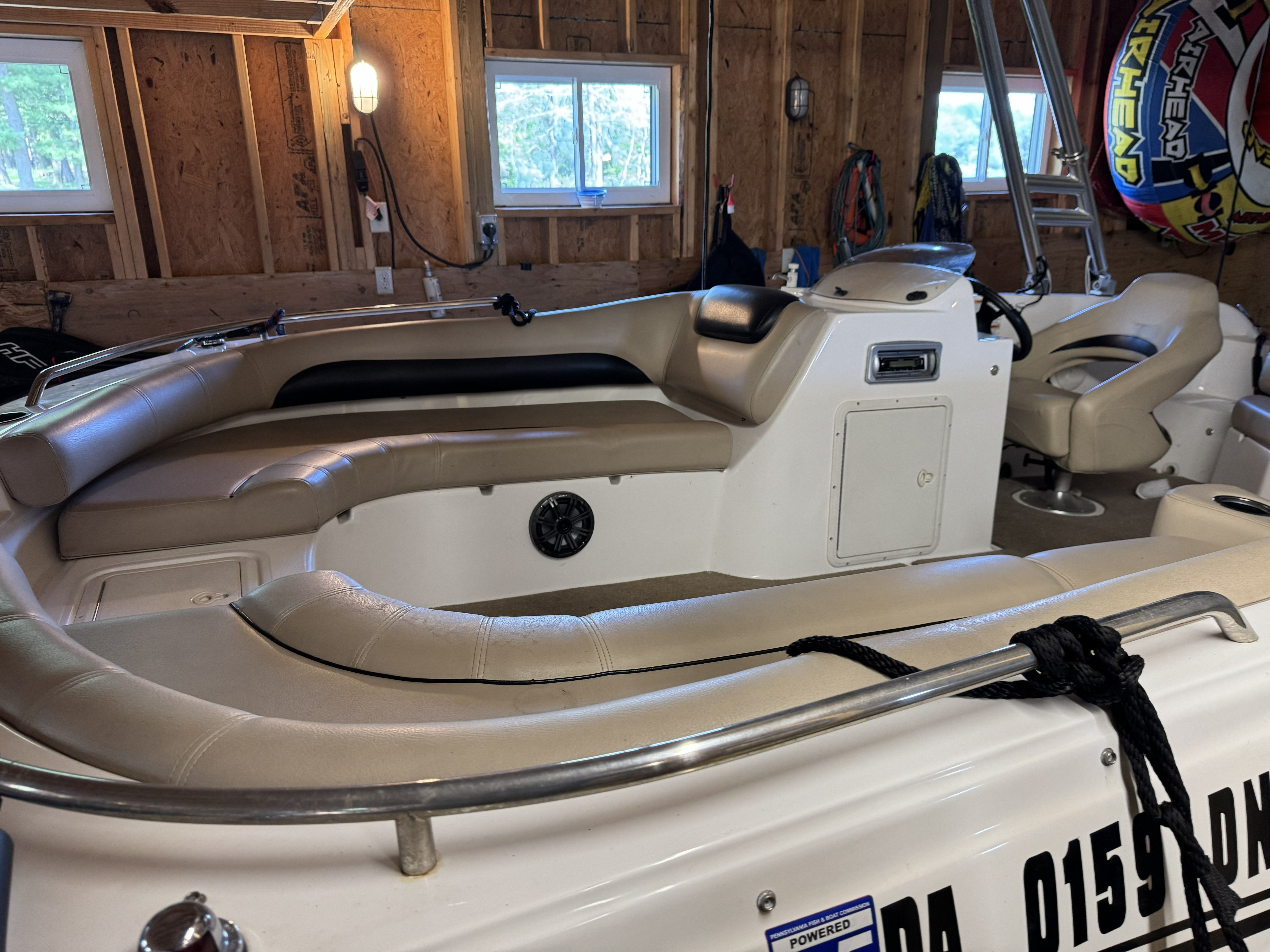 Interior view of a 2014 Hurricane SS201 I/O boat with beige seating in a garage.