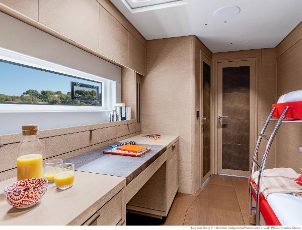 Luxurious interior of 2025 Lagoon SIXTY 5 yacht cabin with modern furnishings and natural light.