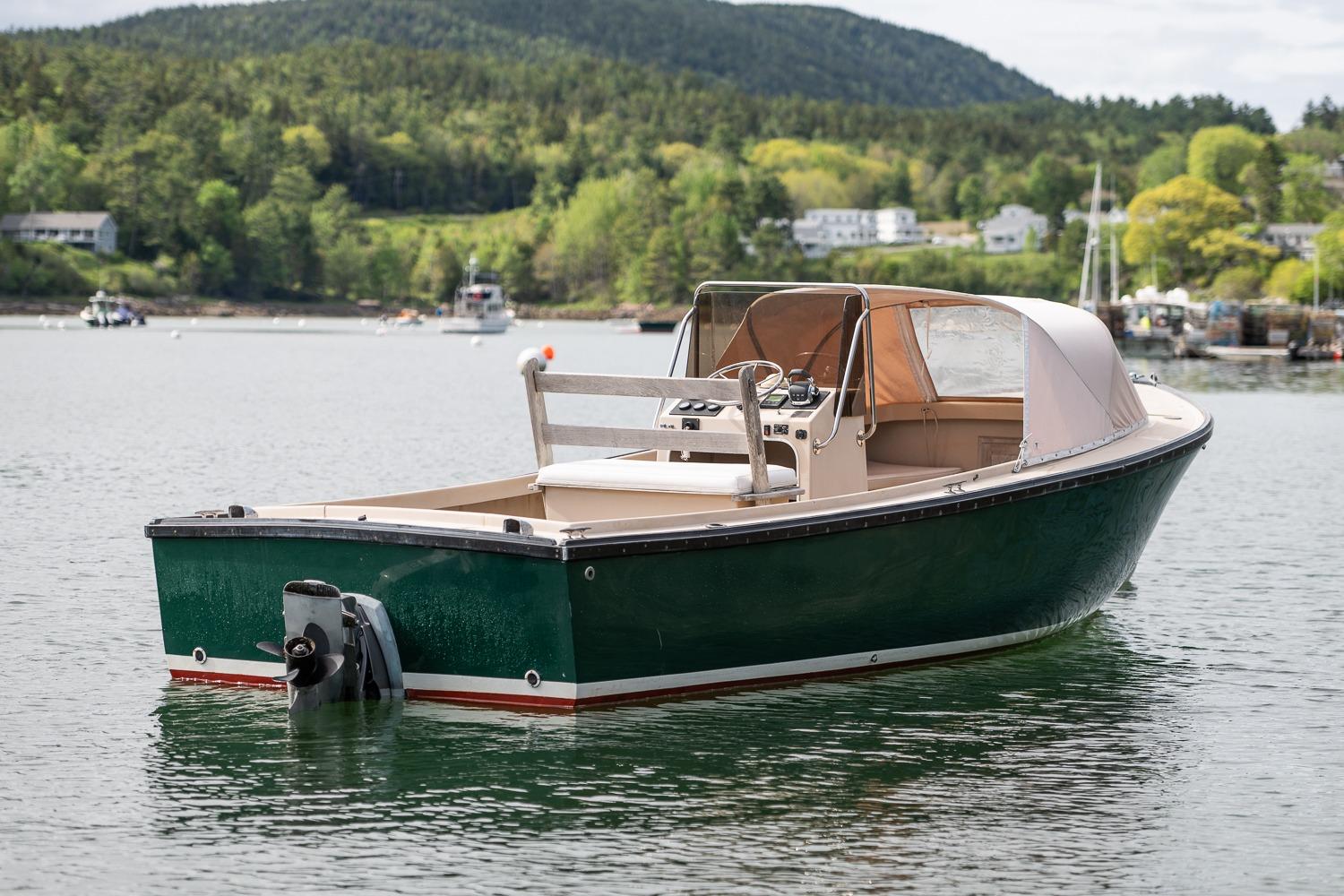 1989 Ellis 24 Open boat on calm water with scenic forested background.