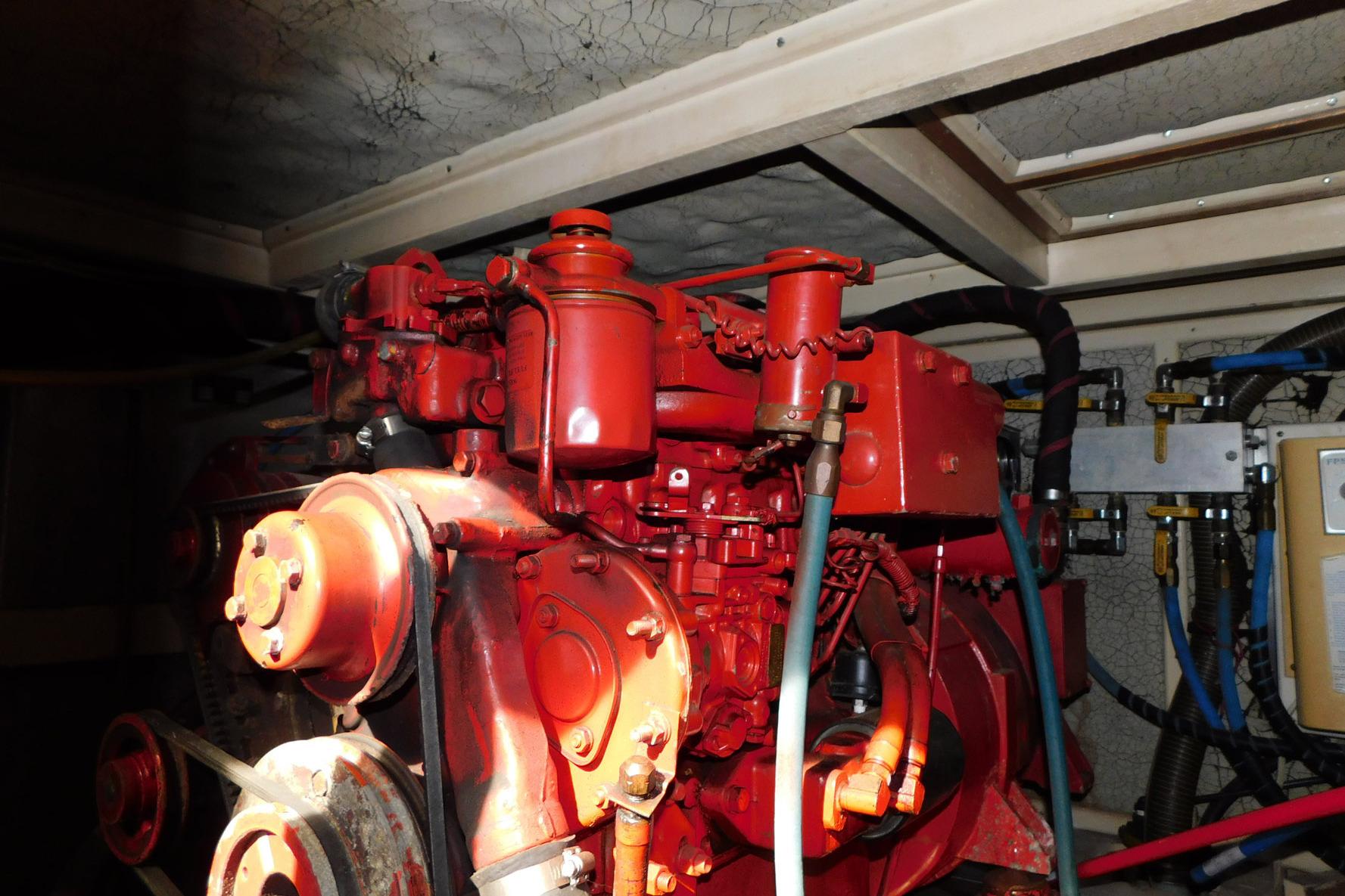 Engine room of 1986 Grand Banks 46 Classic yacht with red machinery components.