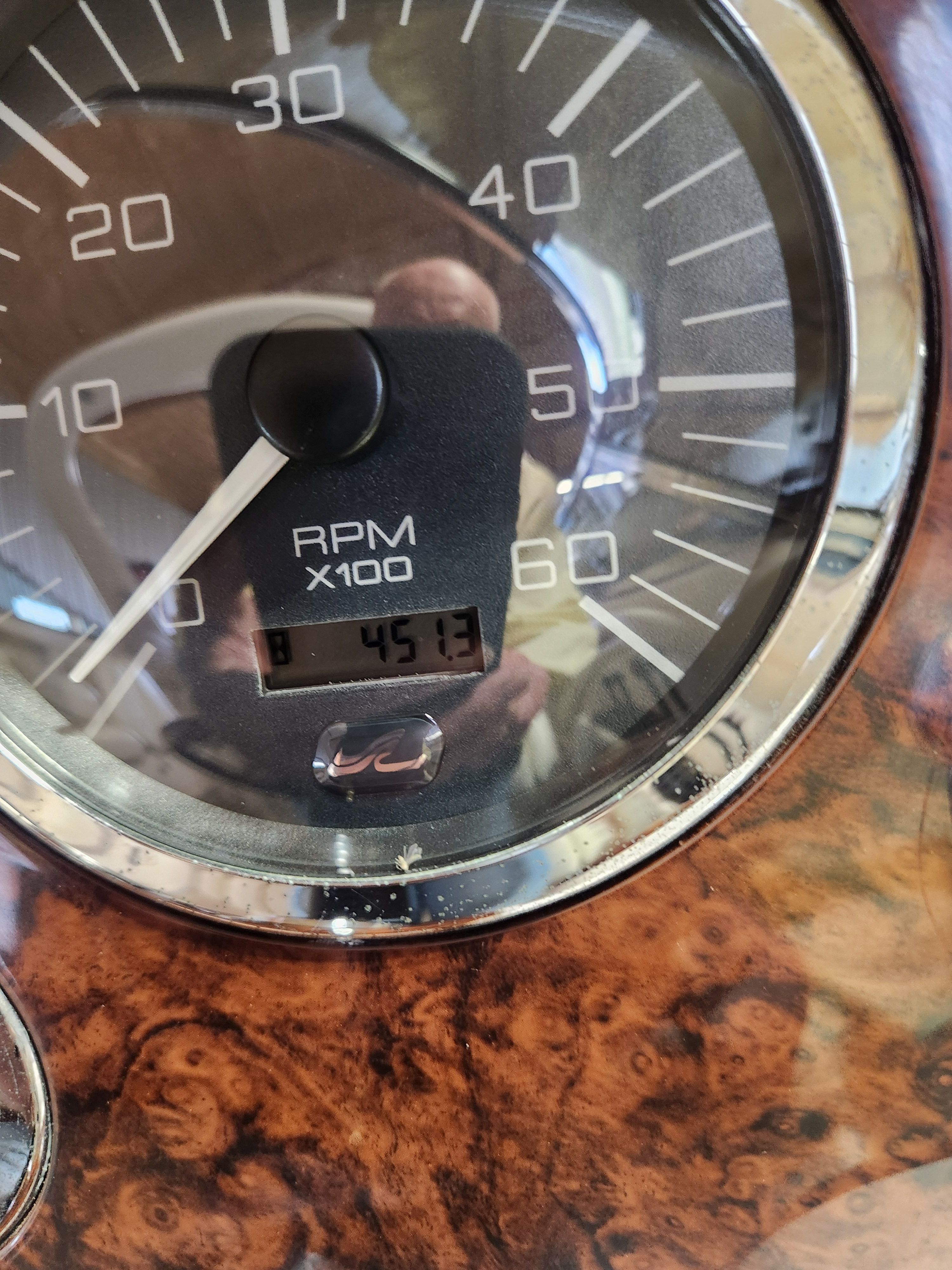 Close-up of a tachometer with wood trim, displaying 451.3 RPM.