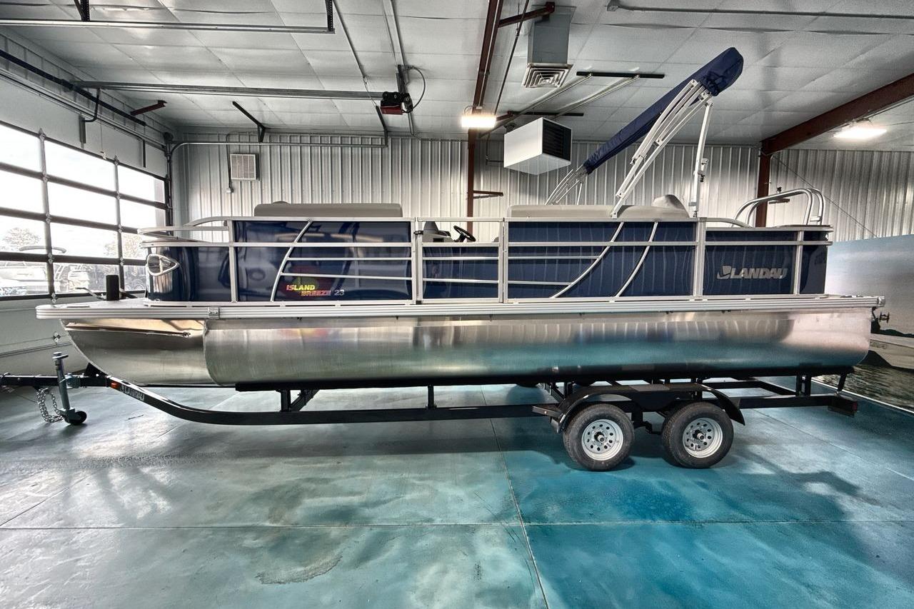 2026 Landau Island Breeze 23F pontoon boat in a showroom on a trailer.