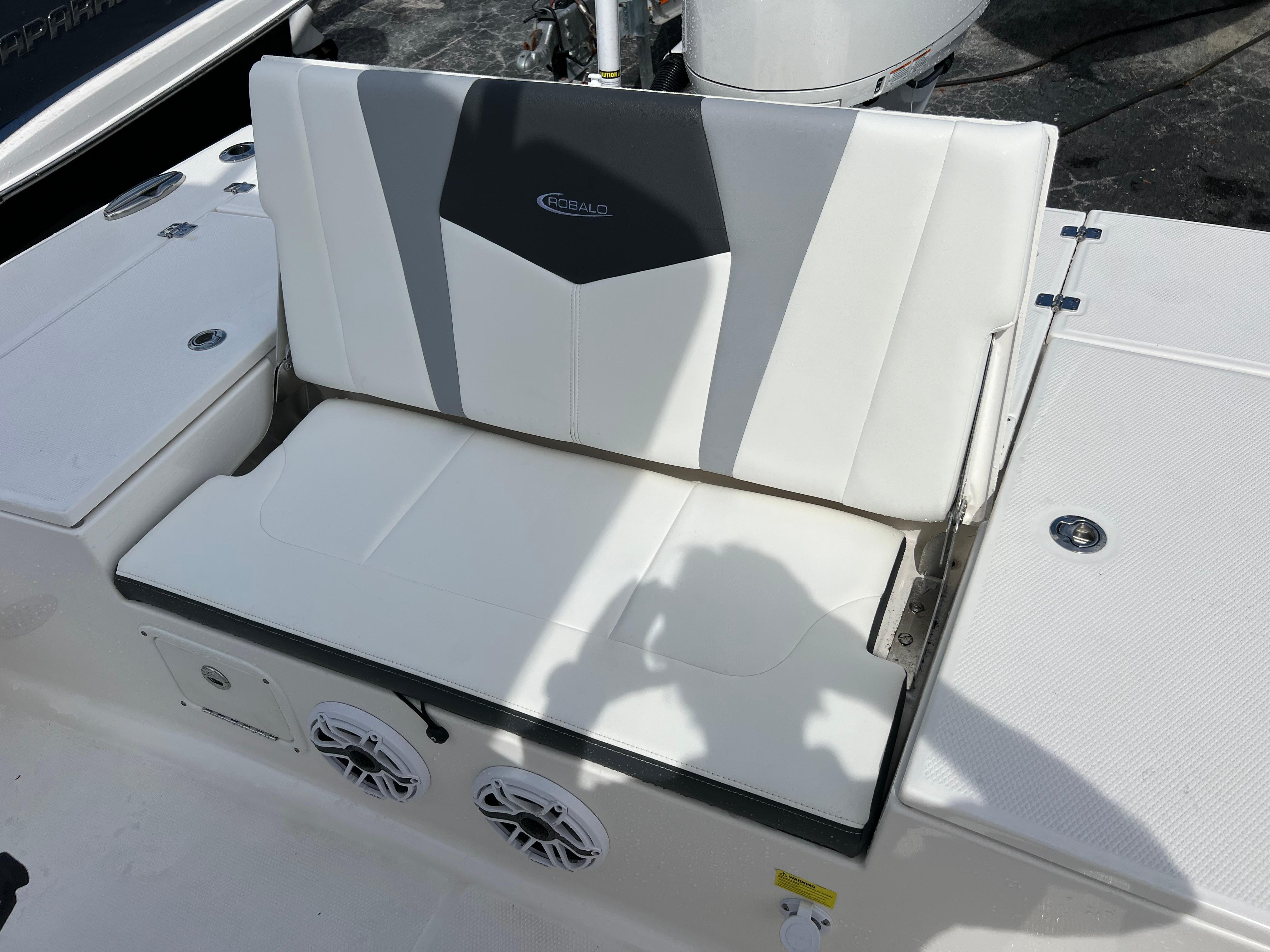 2024 Robalo 246 Sky Deck boat with white cushioned seating and built-in speakers.
