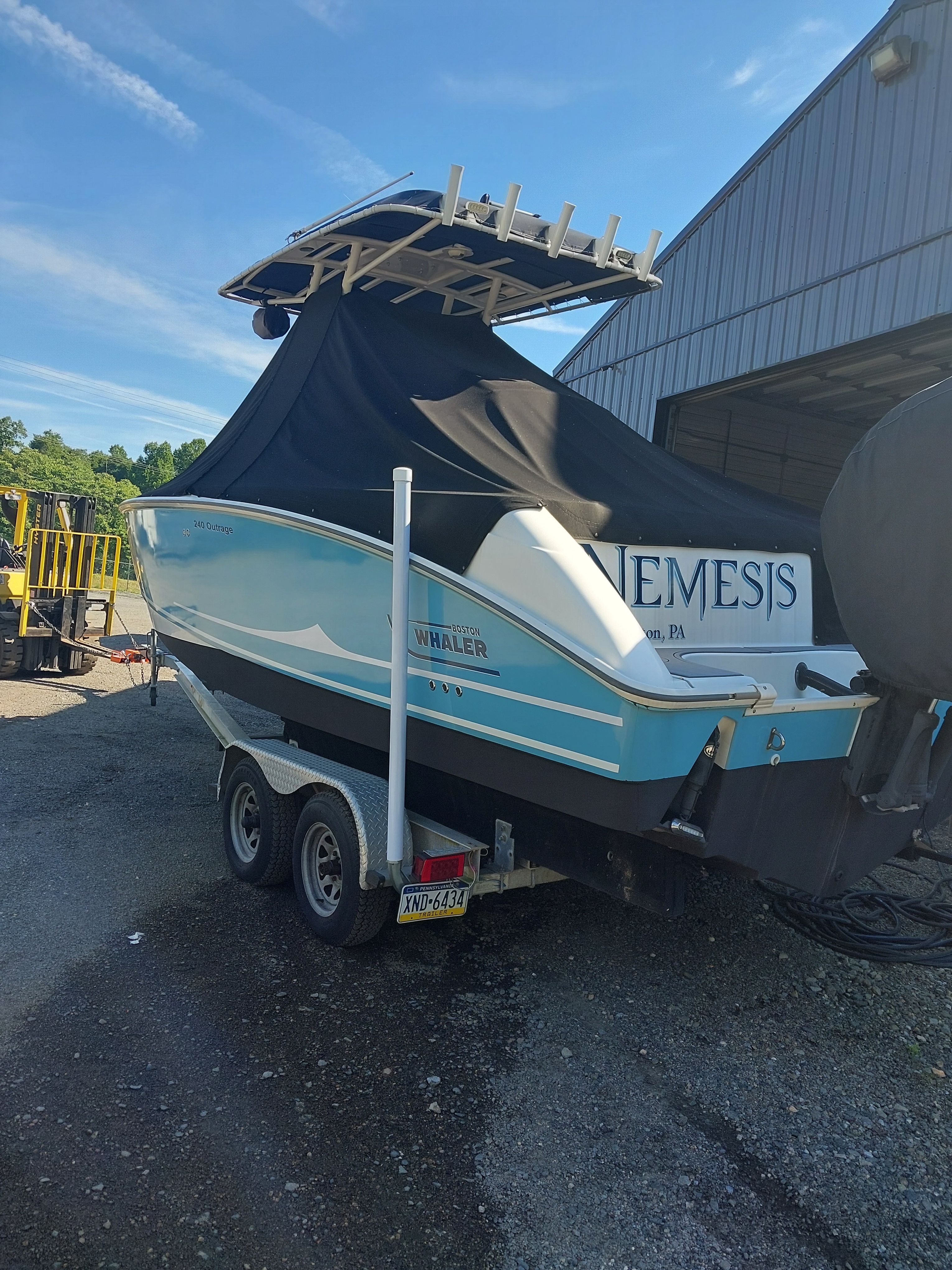 A 2005 Boston Whaler 240 Outrage on a trailer beside a building.