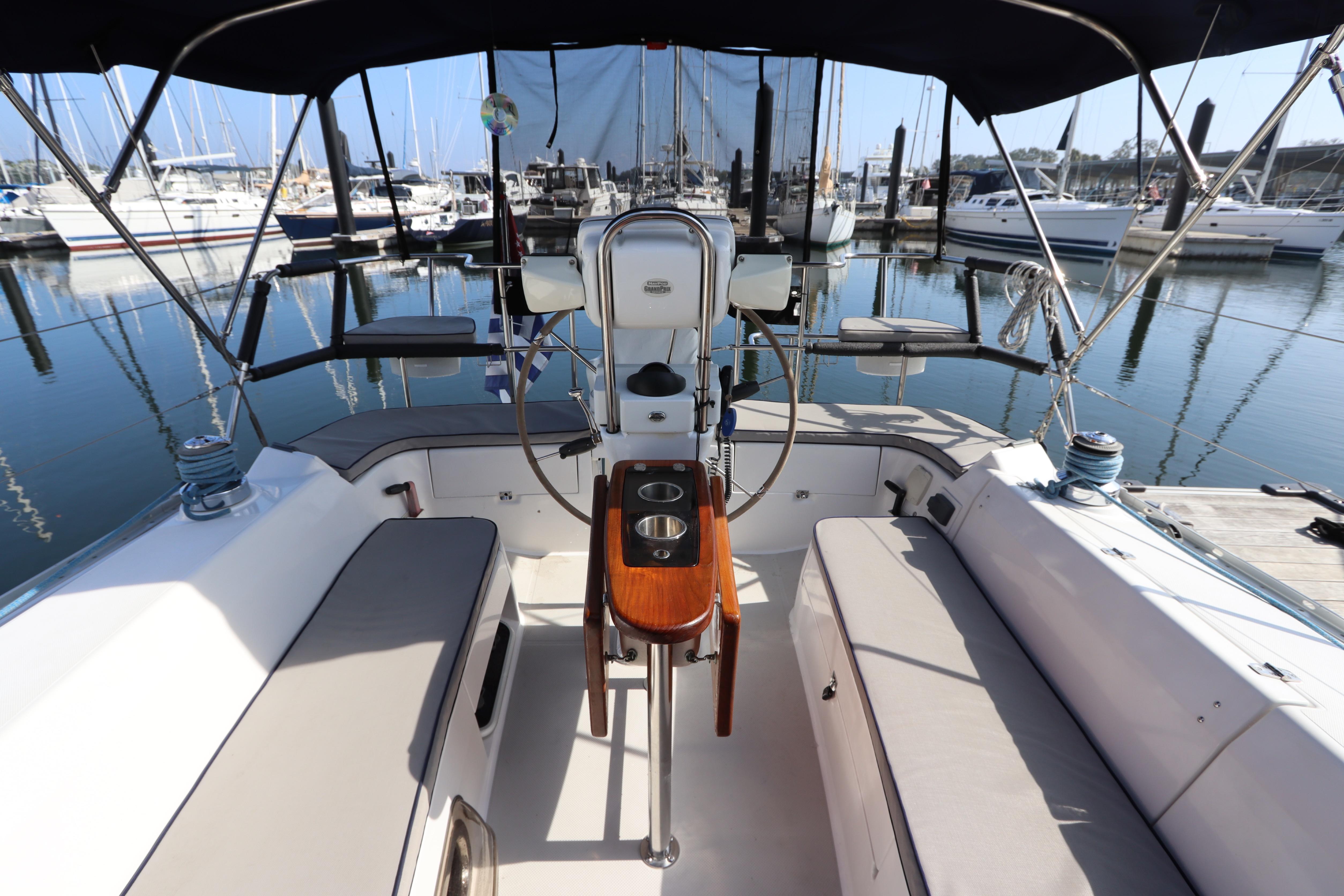 Cockpit of 2011 Catalina 355 sailboat docked at marina, featuring comfortable seating and steering wheel.