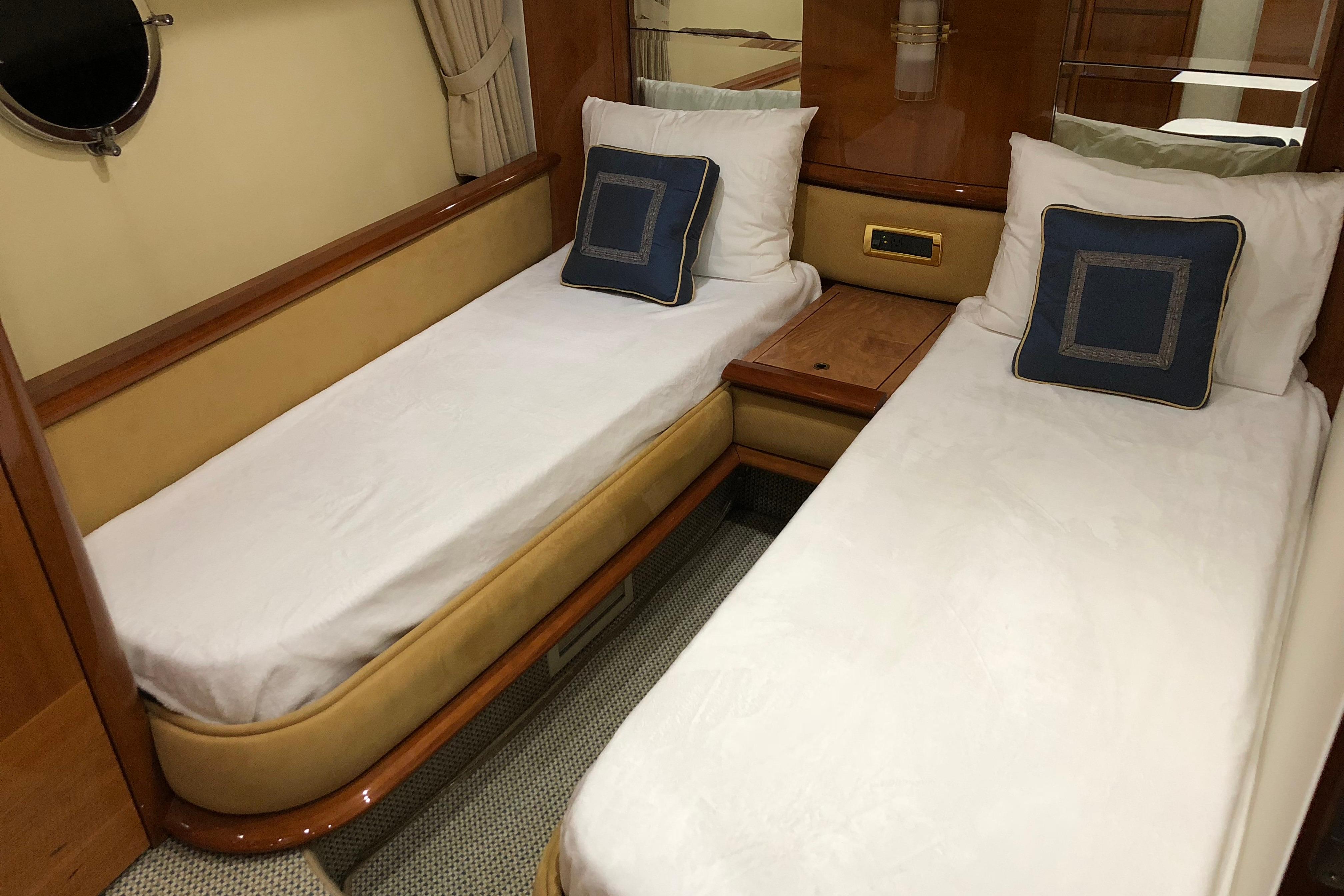 Twin cabin interior of 2007 Azimut 62 Evolution yacht with elegant bedding and wood accents.