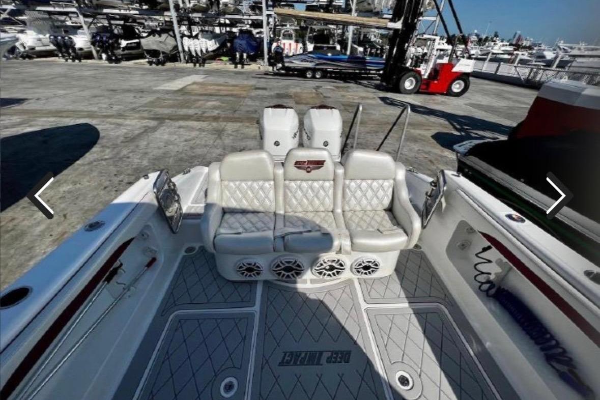 2015 Deep Impact 33 boat interior with cushioned seating and speakers at a marina.