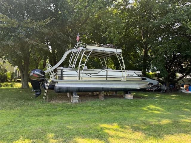 2017 Crest Caribbean 250 L pontoon boat on blocks, surrounded by trees and grass.