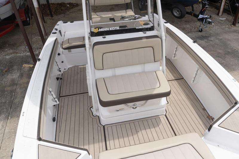 2023 Yamaha Boats 195 FSH Sport interior with beige seating and Minn Kota equipment.