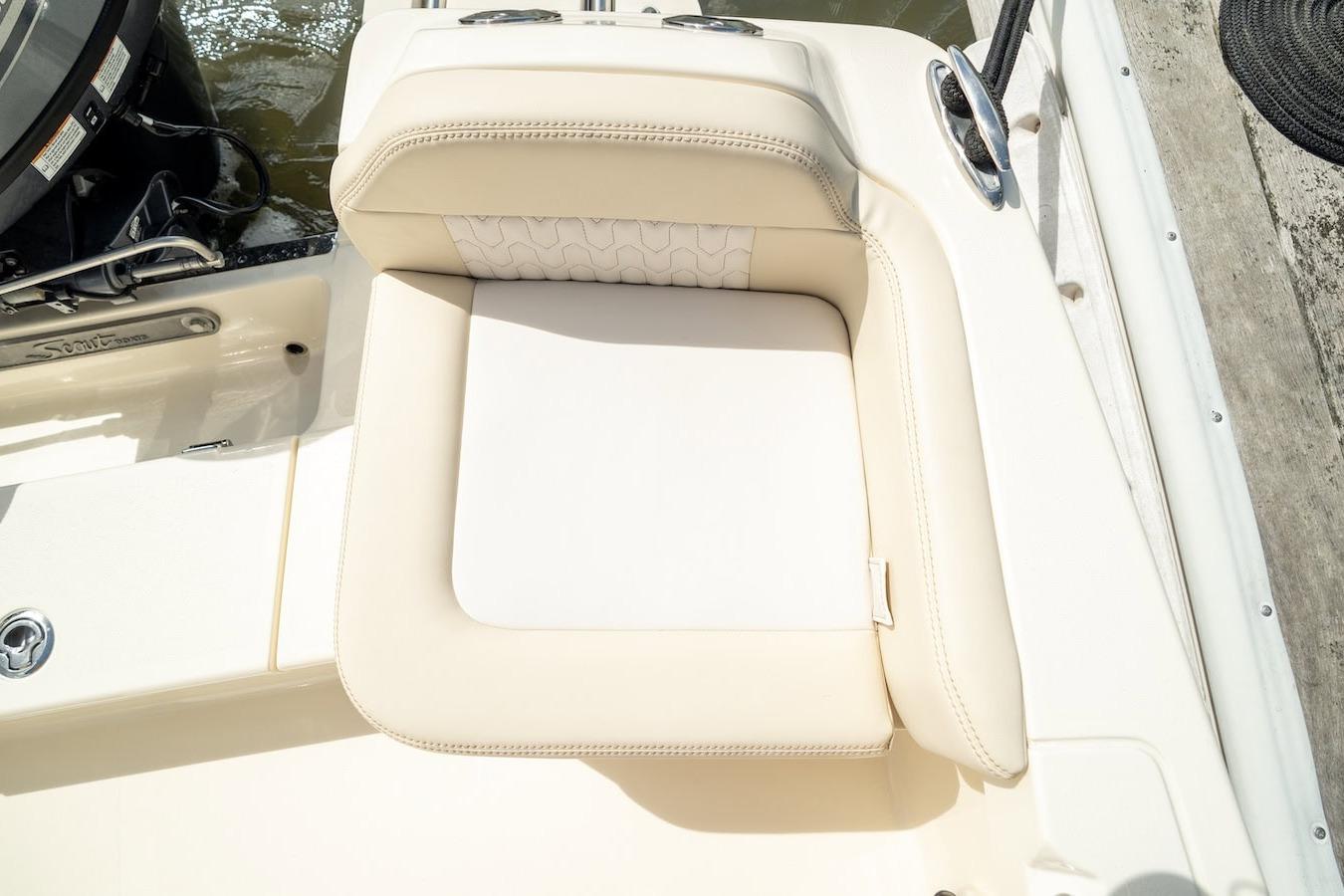 2026 Scout 188 Sportfish boat seat, beige upholstery, docked by water.