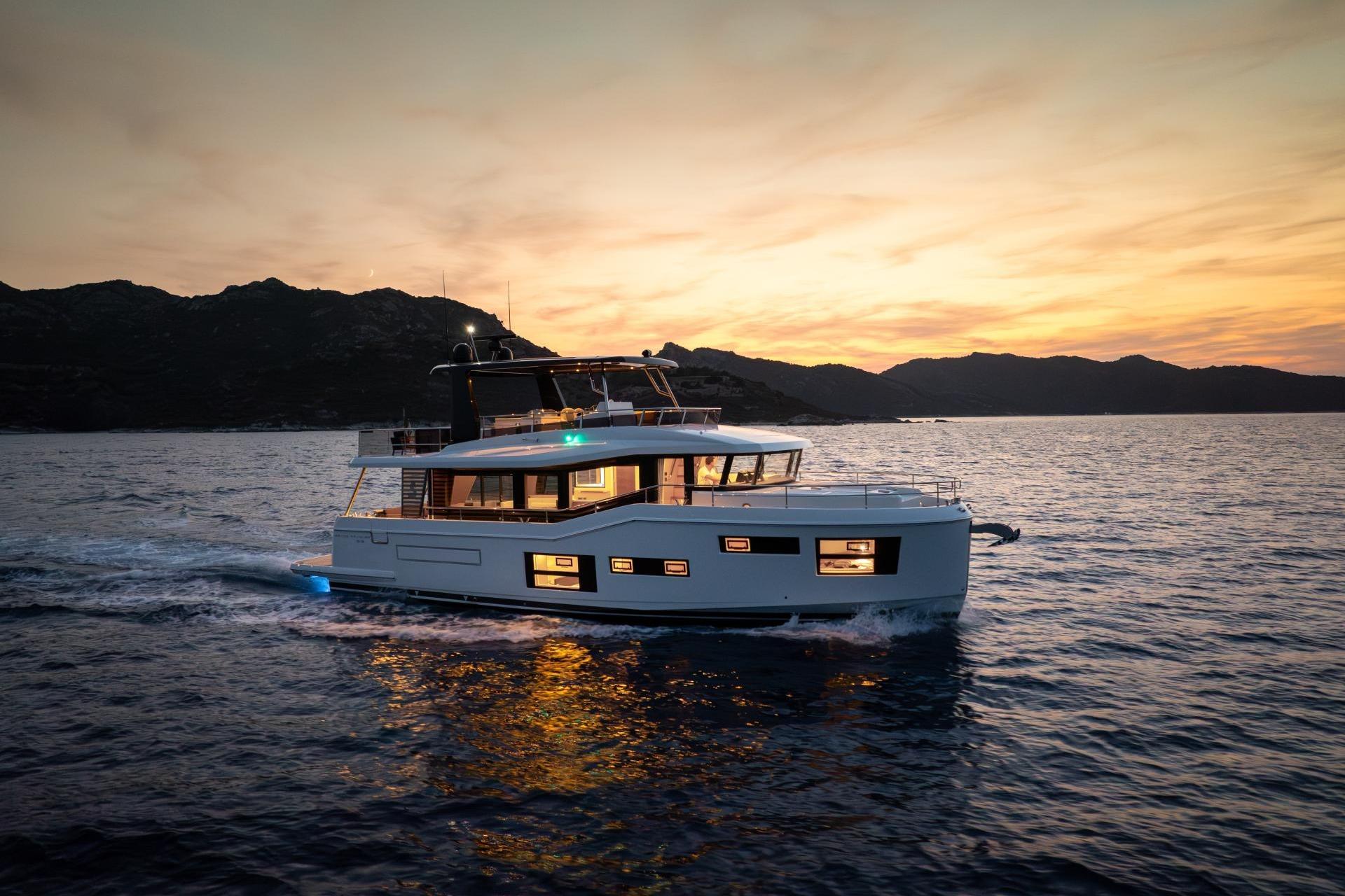 2026 Beneteau Grand Trawler 63 cruising at sunset, scenic ocean view.