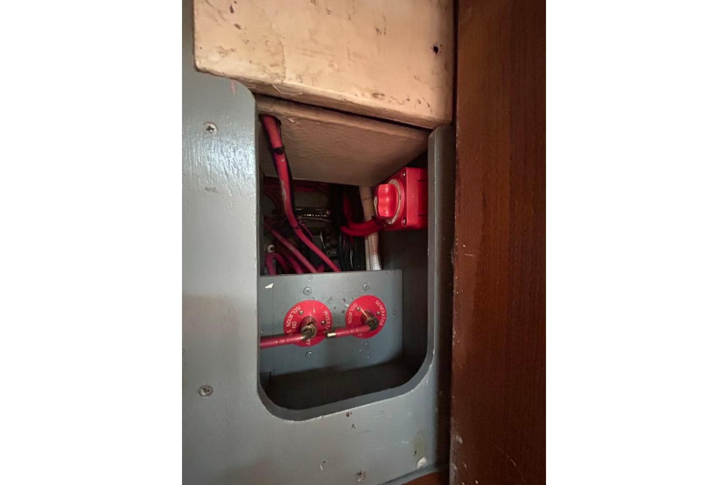 Electrical panel with red switches and cables inside a Hardy Commodore 50, 2005 model.