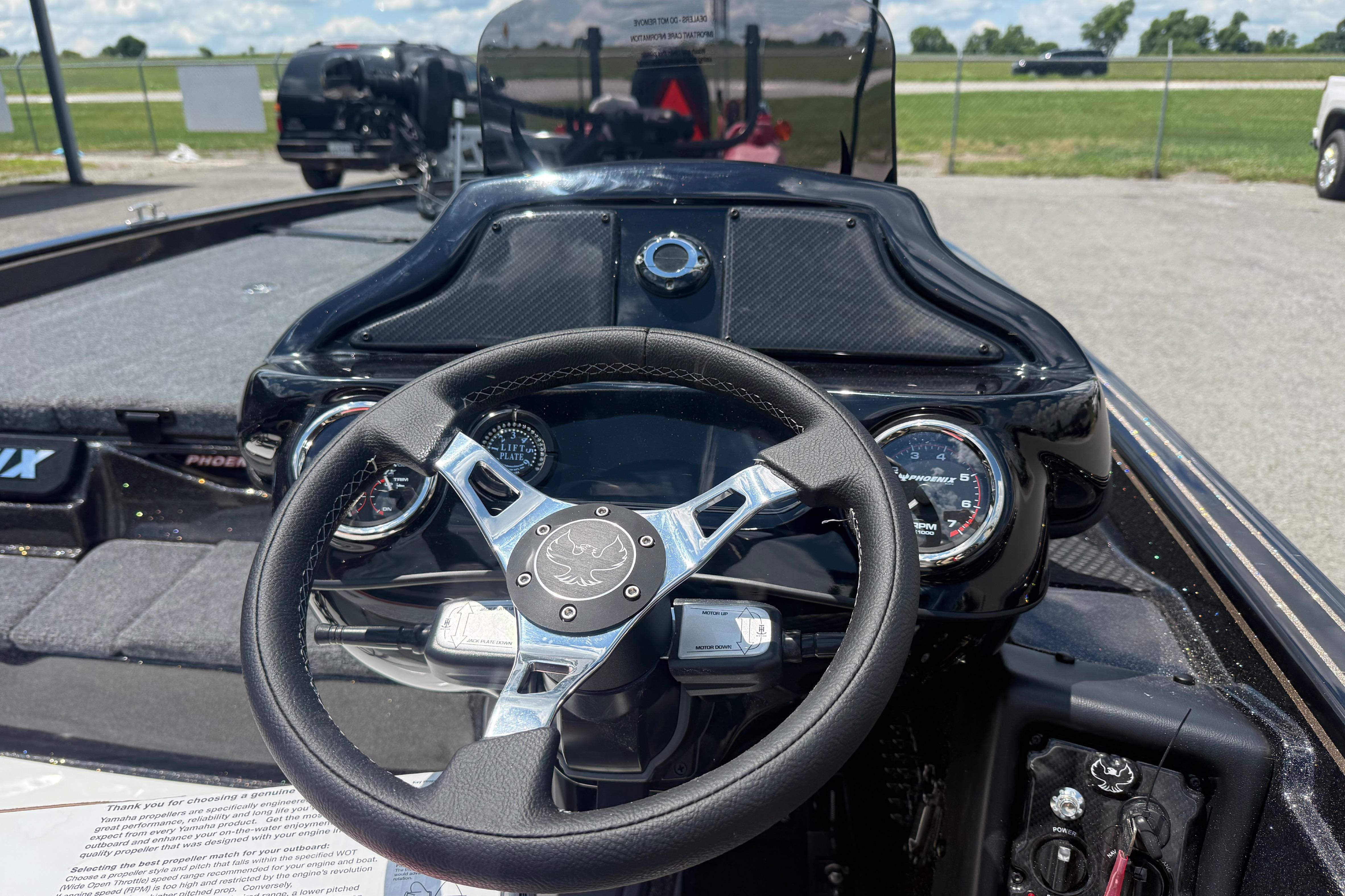 Steering wheel and dashboard of 2027 Phoenix 721 ZXL boat, featuring modern gauges.