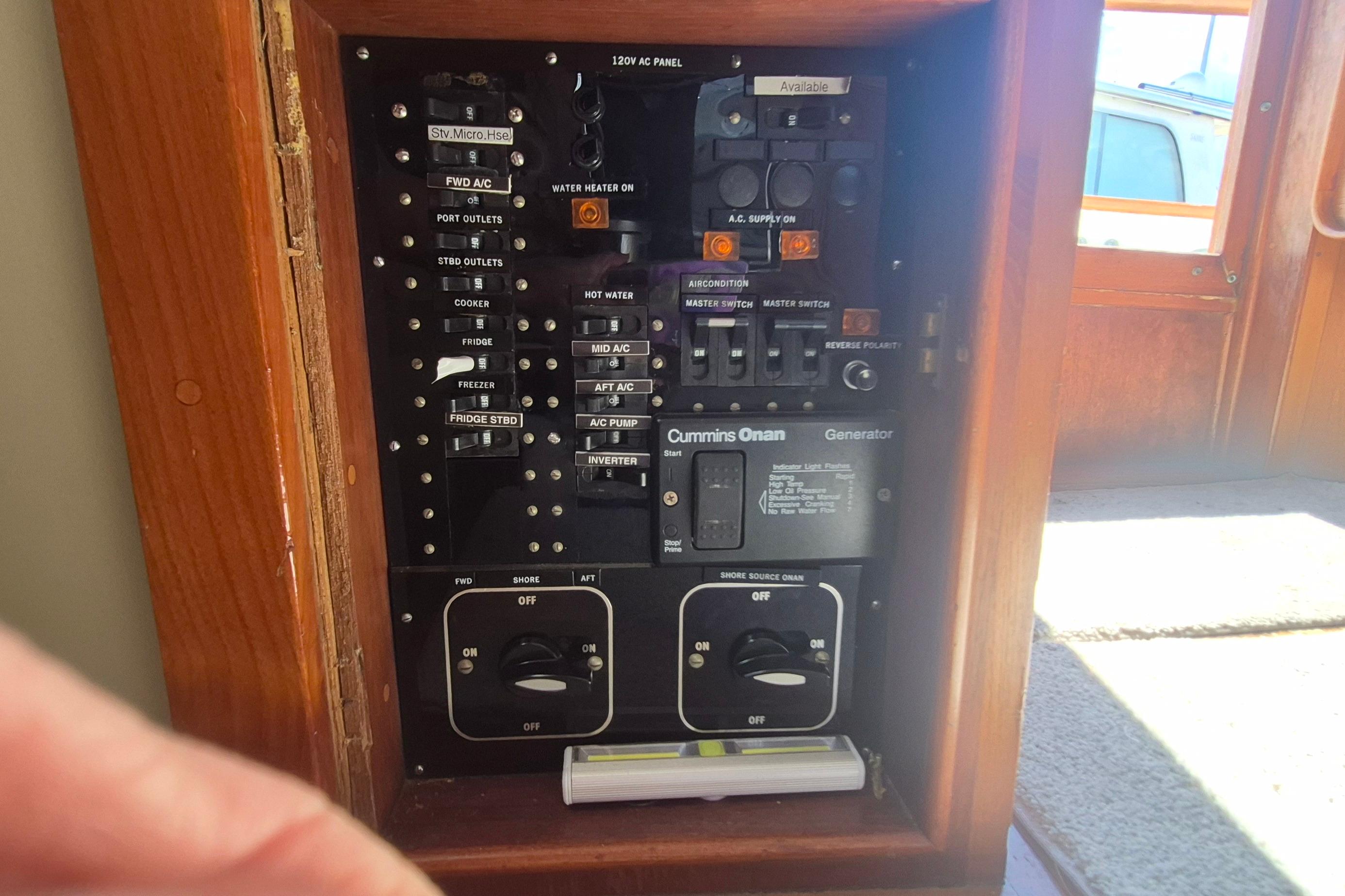 Electrical panel of a 1983 Grand Banks 42 Motoryacht with Cummins Onan generator controls.