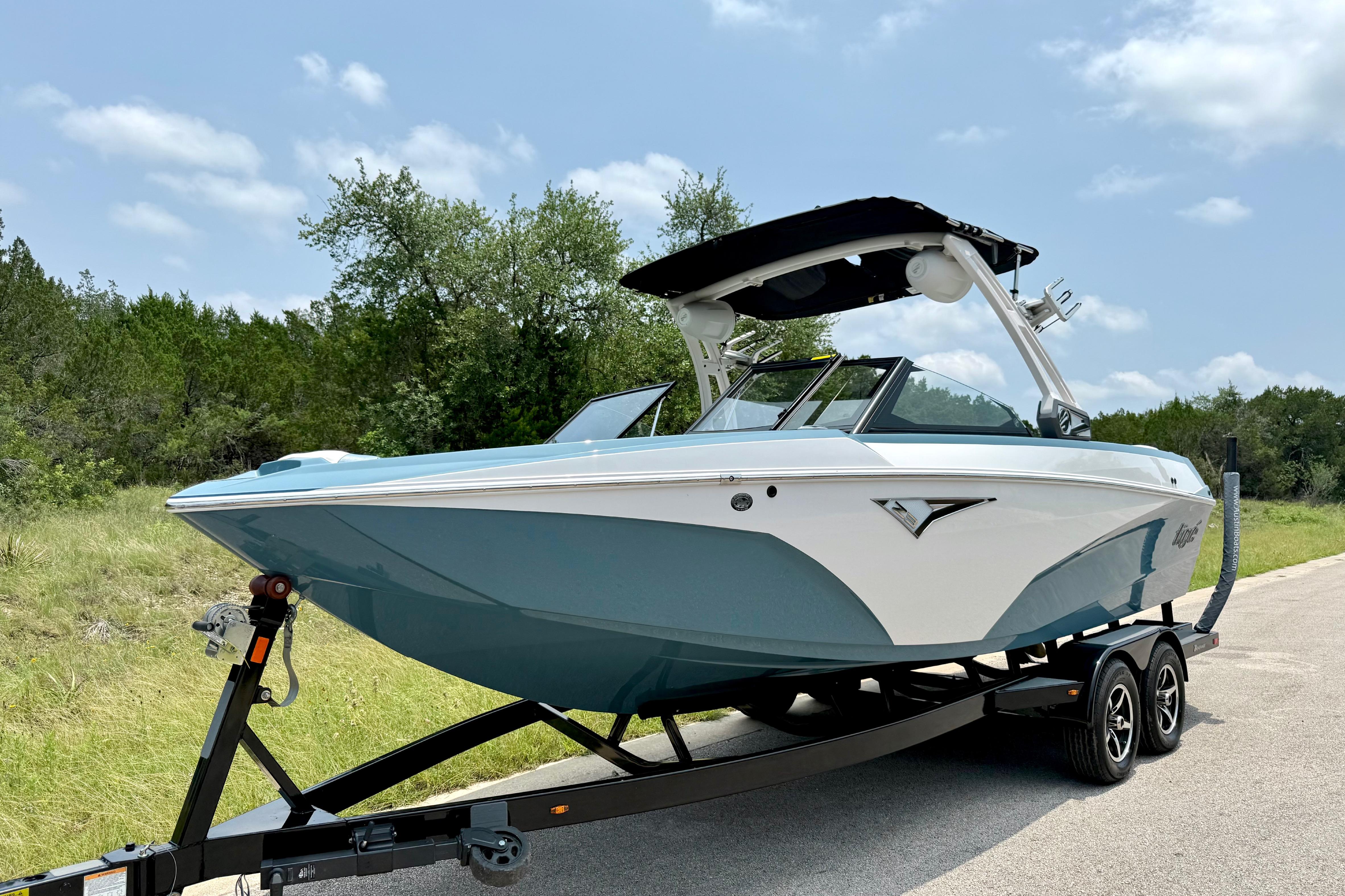 2021 Tige Z3 boat on trailer, parked on roadside with trees in background.