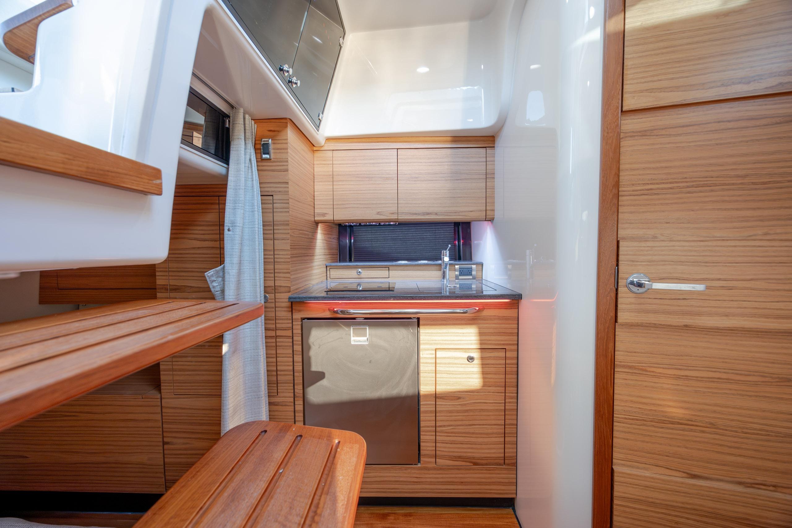 Luxurious interior of 2021 Boston Whaler 405 Conquest yacht with modern kitchen amenities.