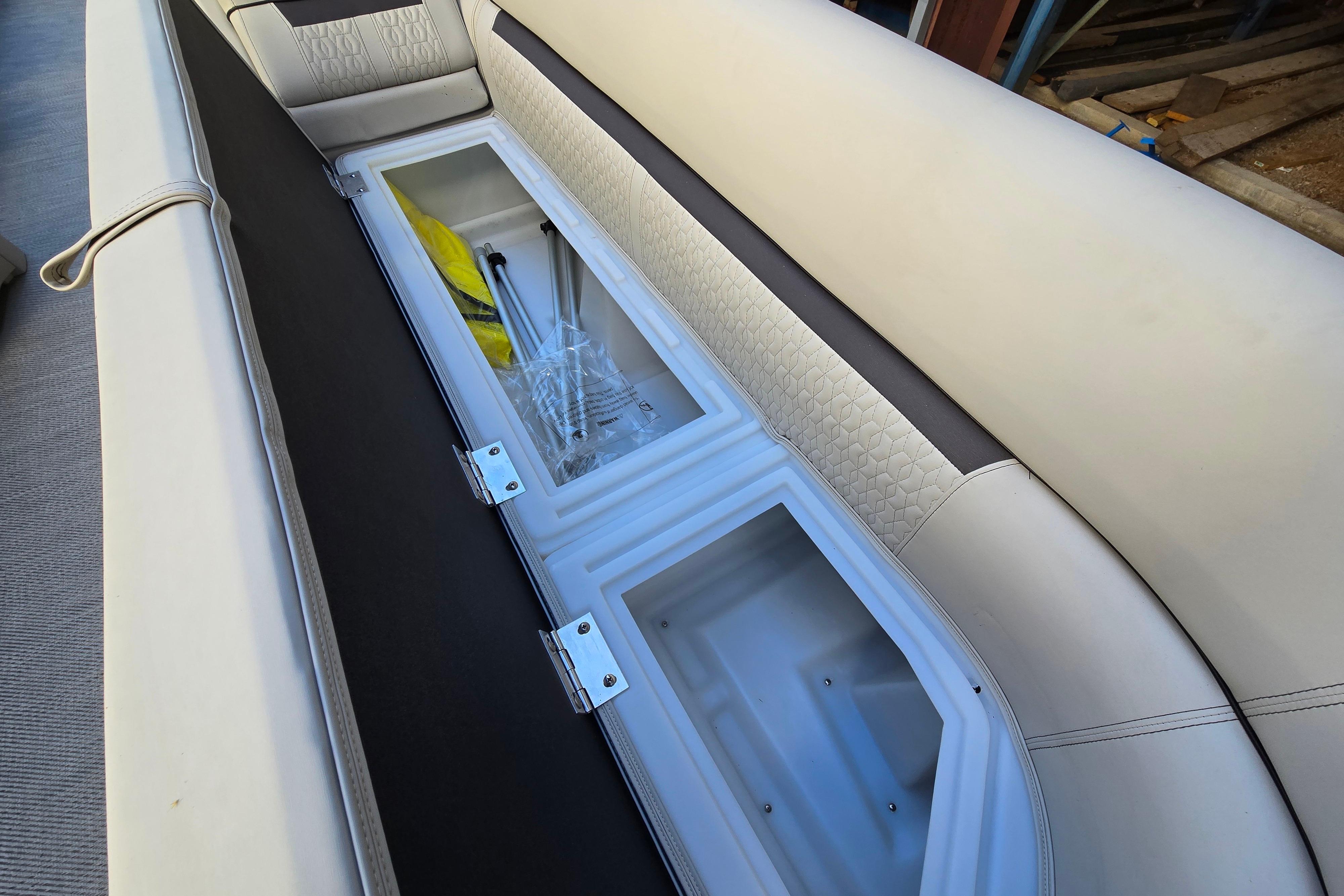 2024 Godfrey Sweetwater 2486 SB boat seat storage compartment with open lid and visible contents.