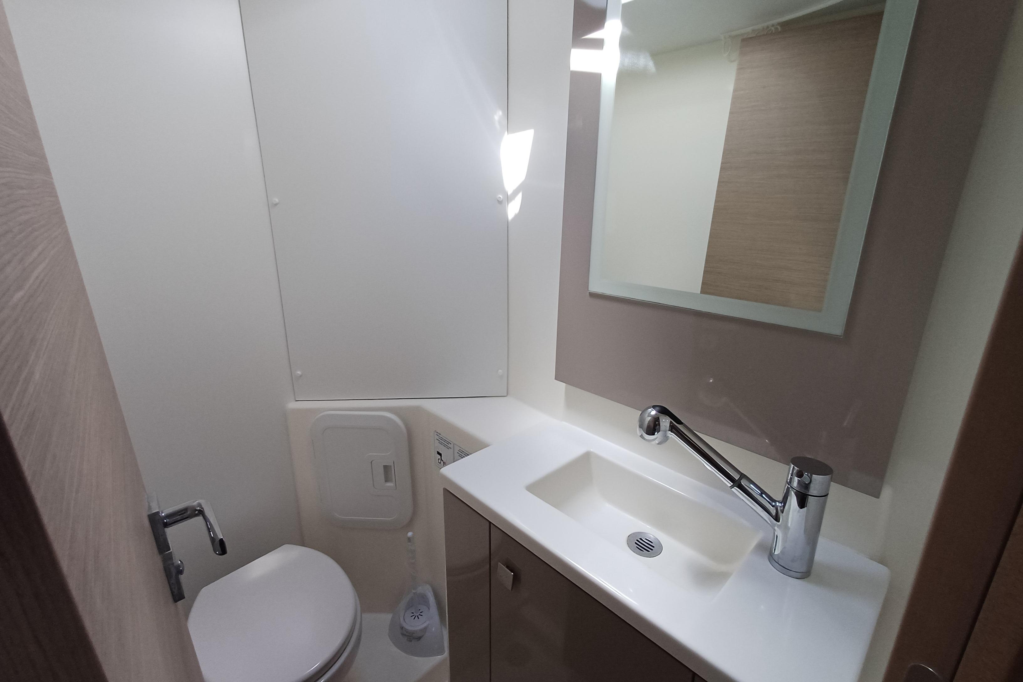 Modern bathroom in 2020 Fountaine Pajot Lucia 40 yacht, featuring sink and toilet.
