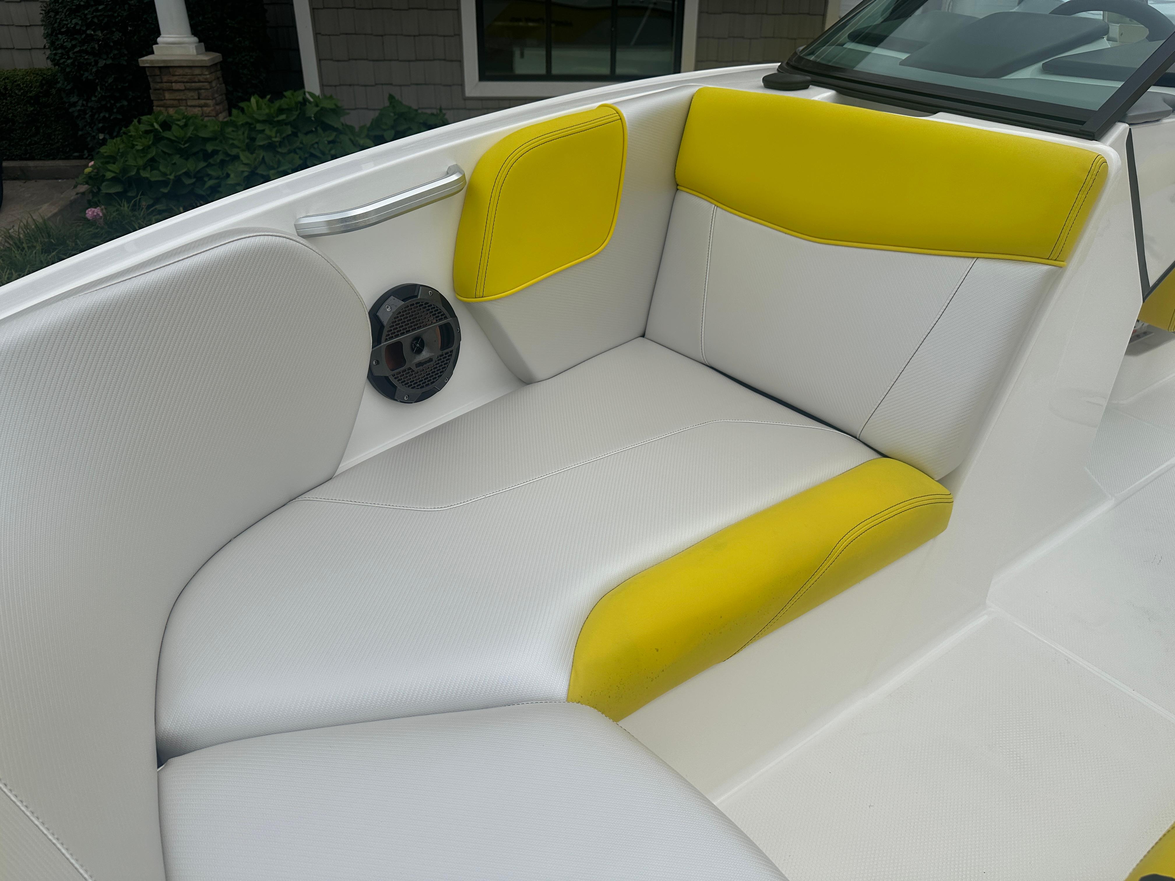 2018 MasterCraft NXT22 boat interior with white and yellow seating, featuring a built-in speaker.