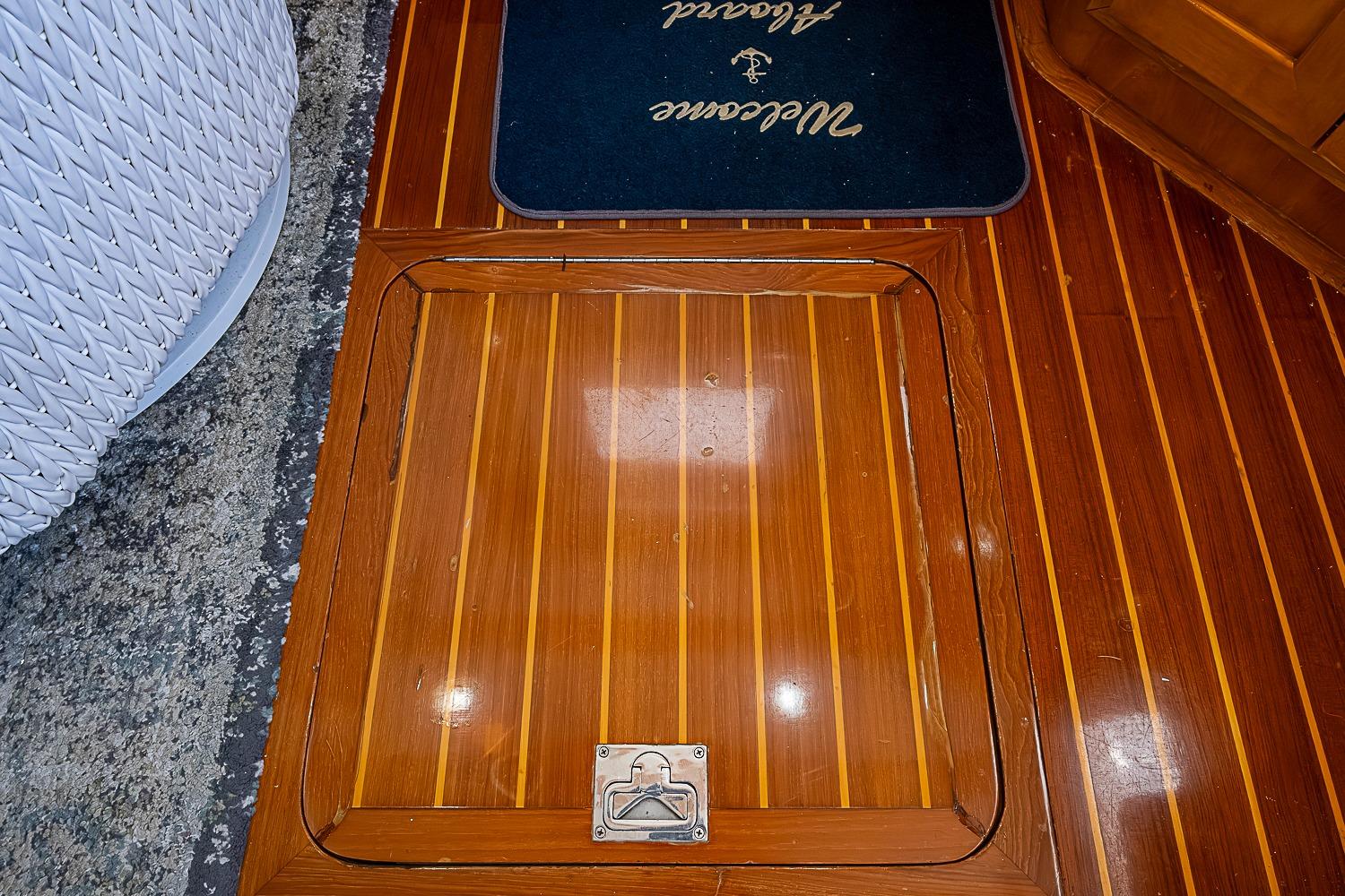 Teak flooring on 2003 Magna Marine Nova Scotia 47 yacht, featuring a hatch and welcome mat.