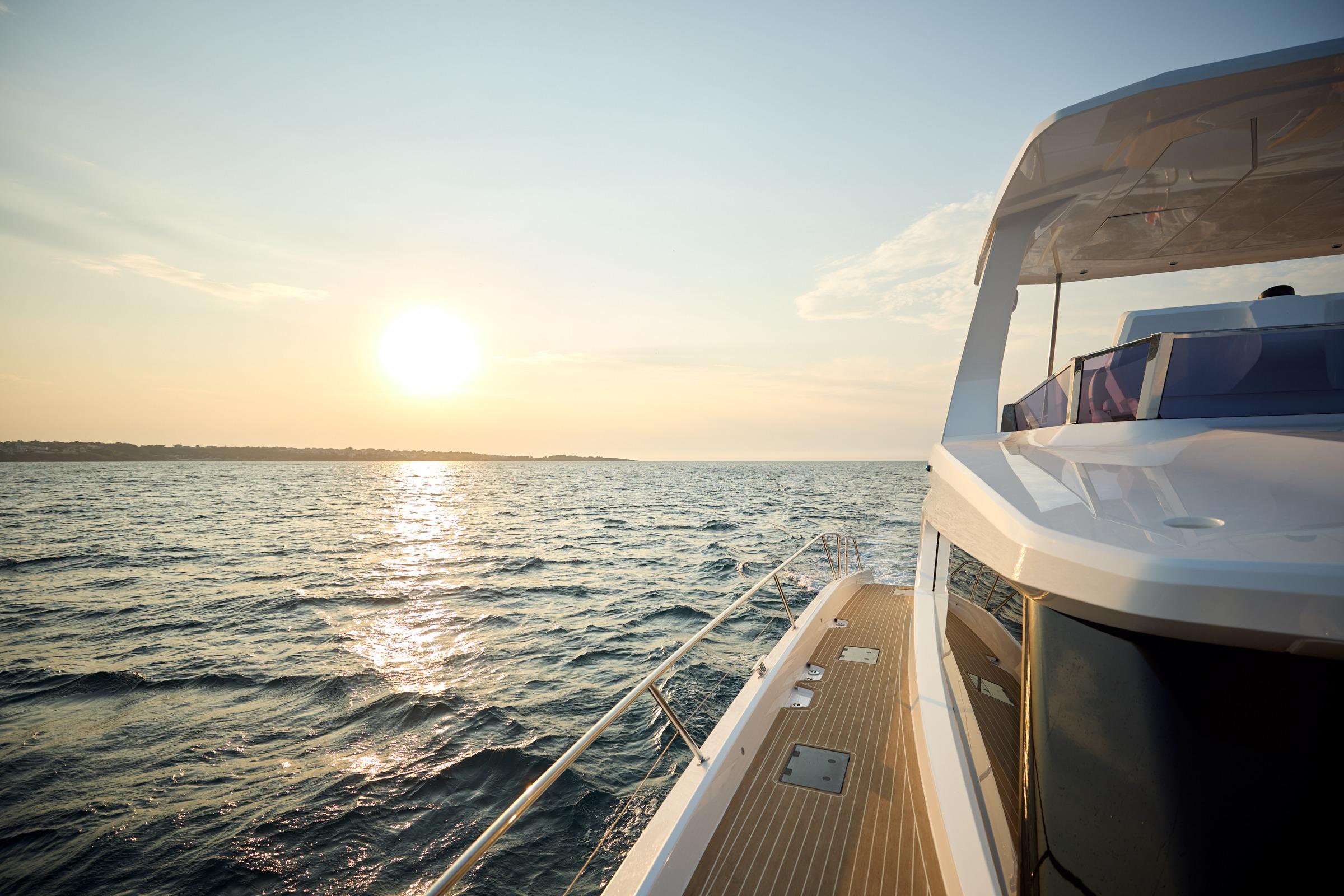 Custom Omaya 50 Power Catamaran cruising at sunset, 2025 model, on open sea.