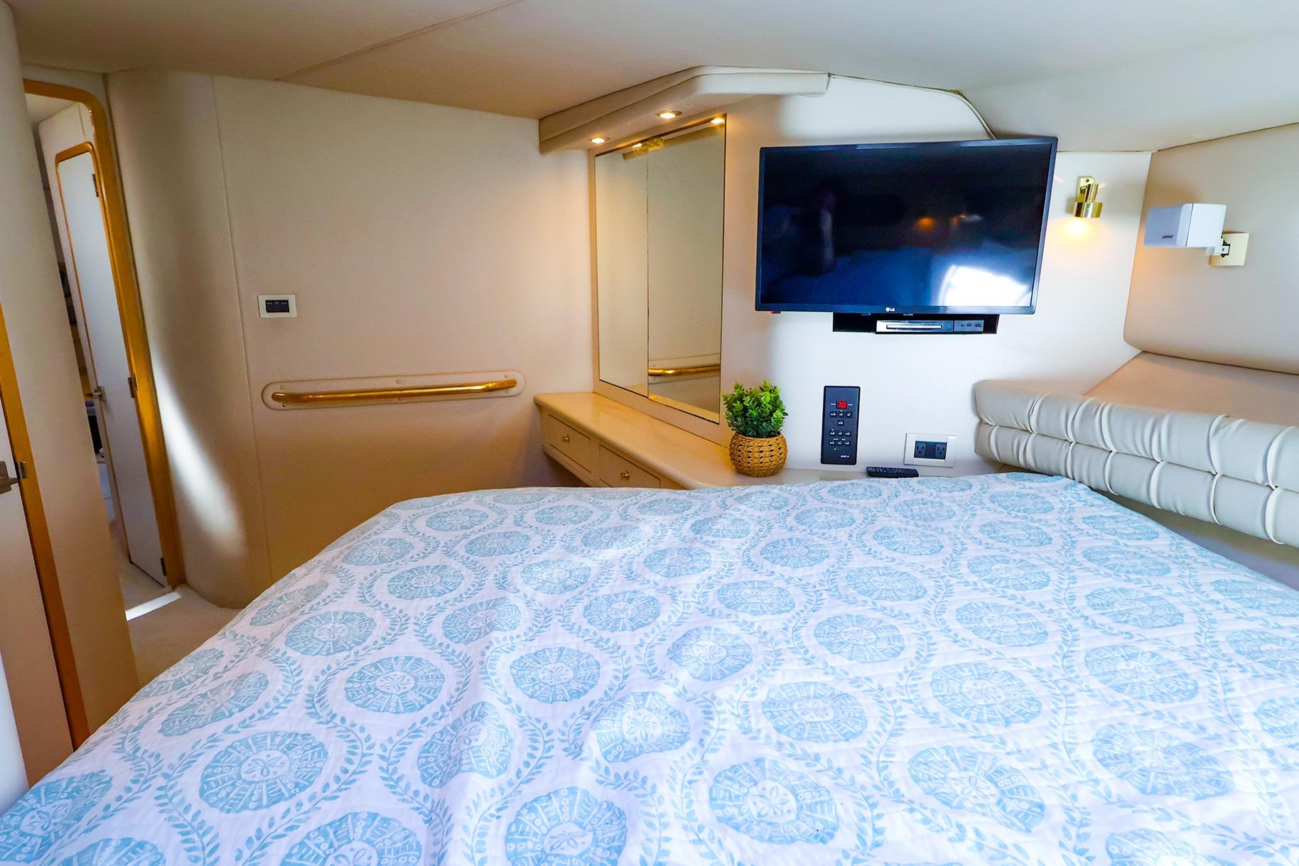 Luxurious 1998 Sea Ray 500 Sundancer cabin with TV, bed, and elegant decor.
