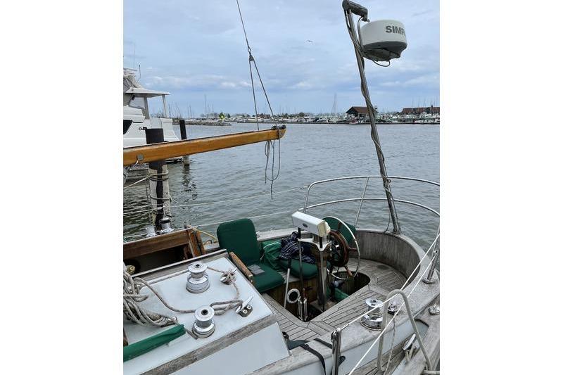 1980 Ta Shing Baba 30 sailboat cockpit with marina view, featuring navigation equipment.