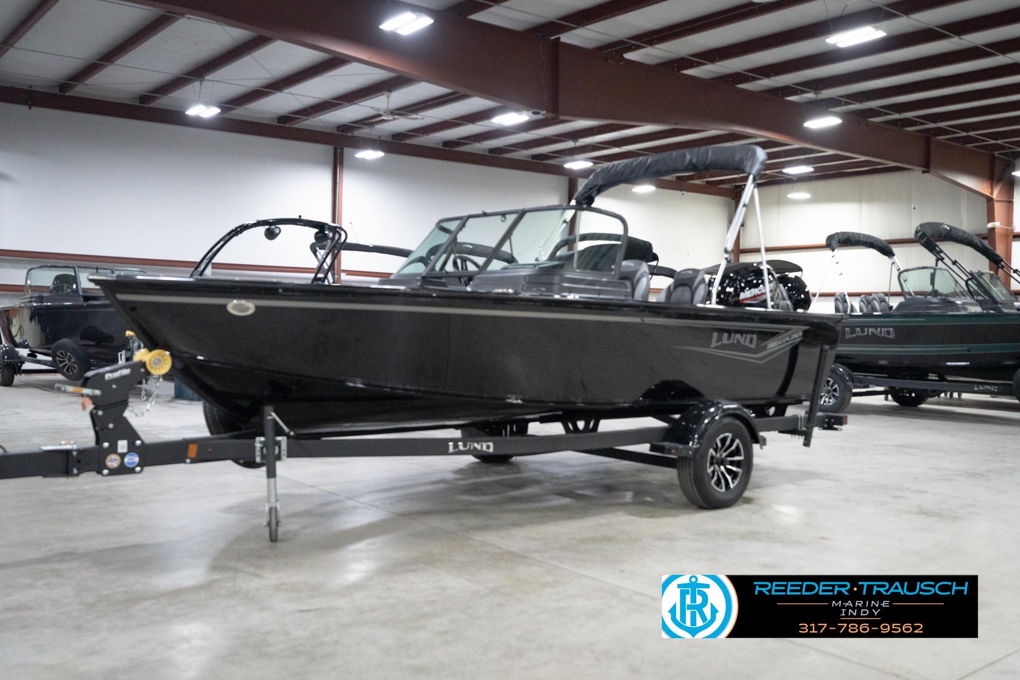 2026 Lund 1800 Explorer Sport boat in showroom, on trailer, with sleek black design.