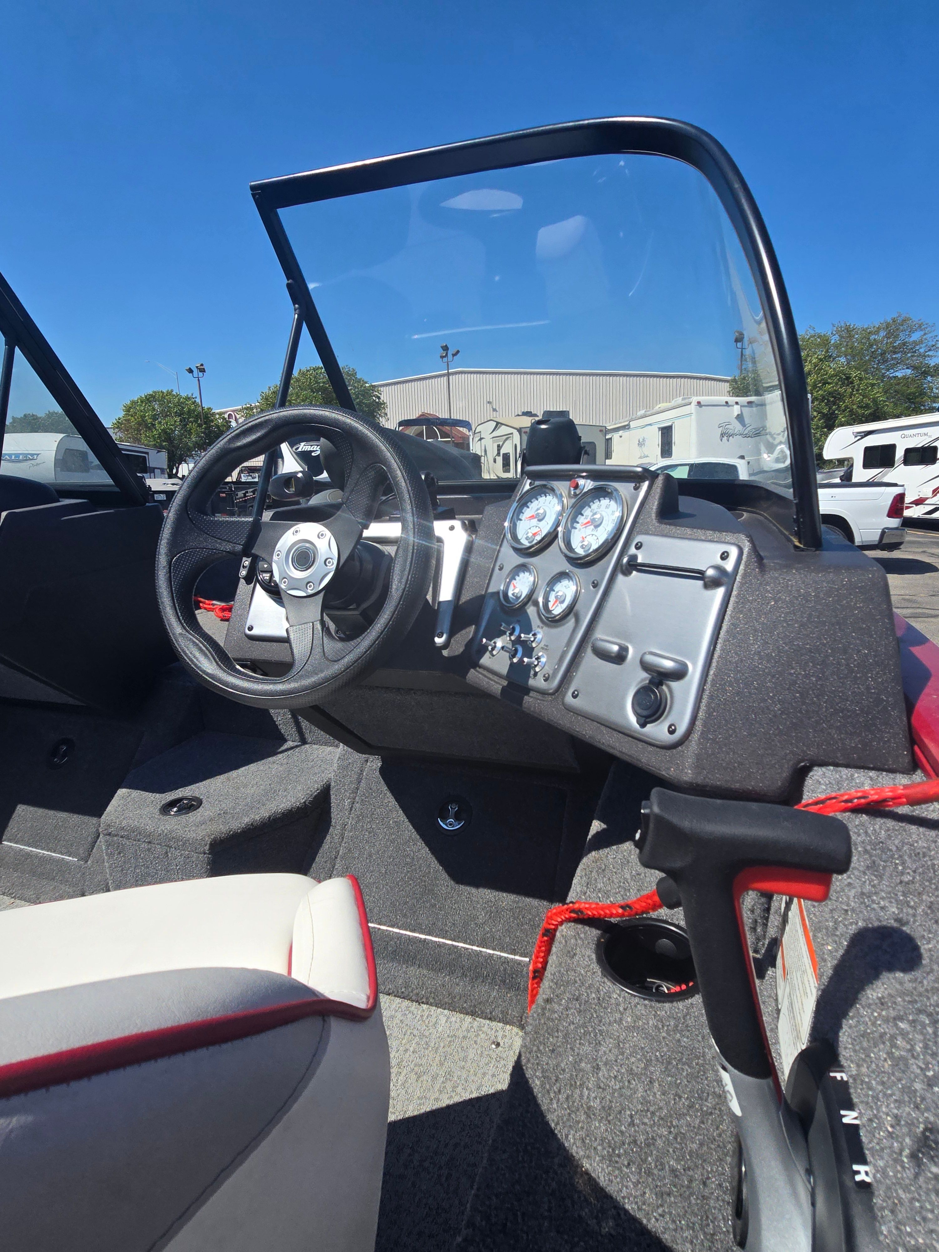 The image shows the cockpit of a 2023 Bass Tracker PGV175 boat with steering wheel and gauges.
