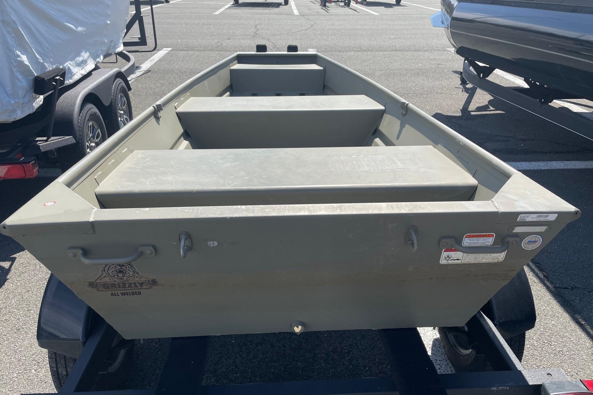 2025 Tracker Grizzly 1236 Jon boat on trailer in parking lot.