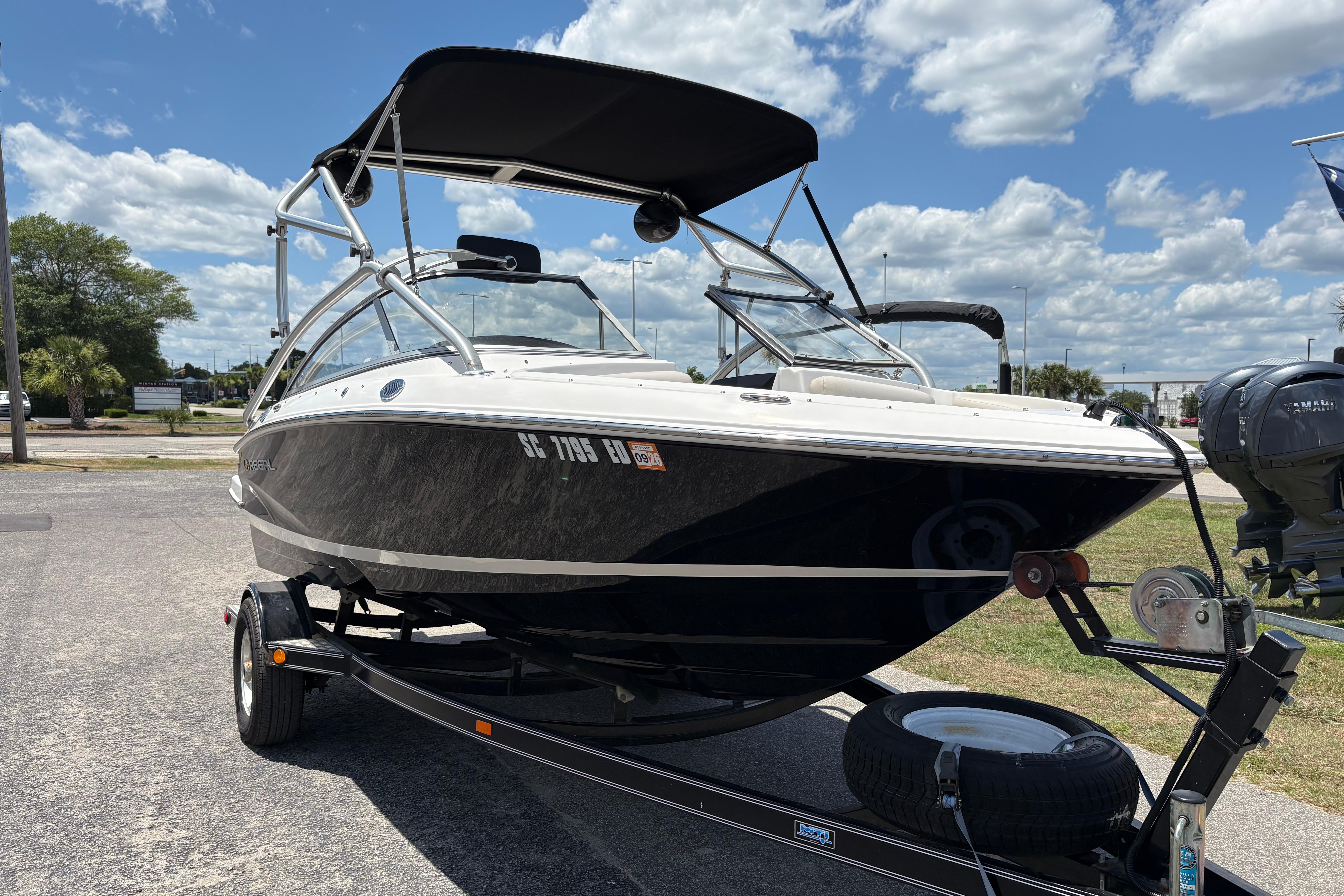 2008 Regal 1900 Bowrider boat on trailer under a partly cloudy sky.