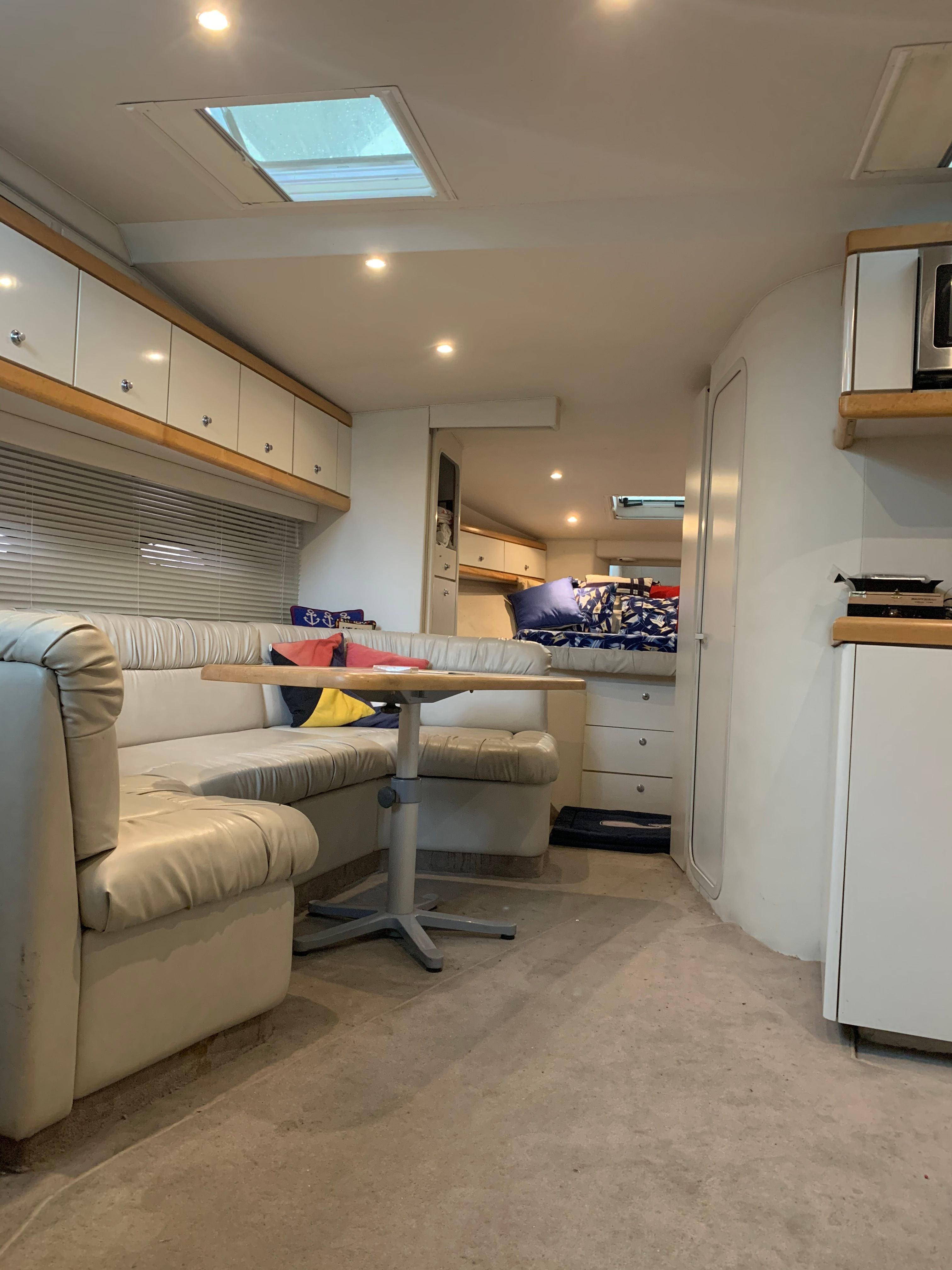 Interior of a 1995 Trojan 390x with seating area, kitchen, and sleeping space.