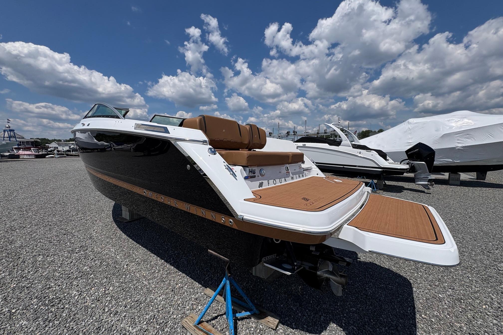 2026 Four Winns H6 boat with sleek design, parked outdoors under a blue sky.
