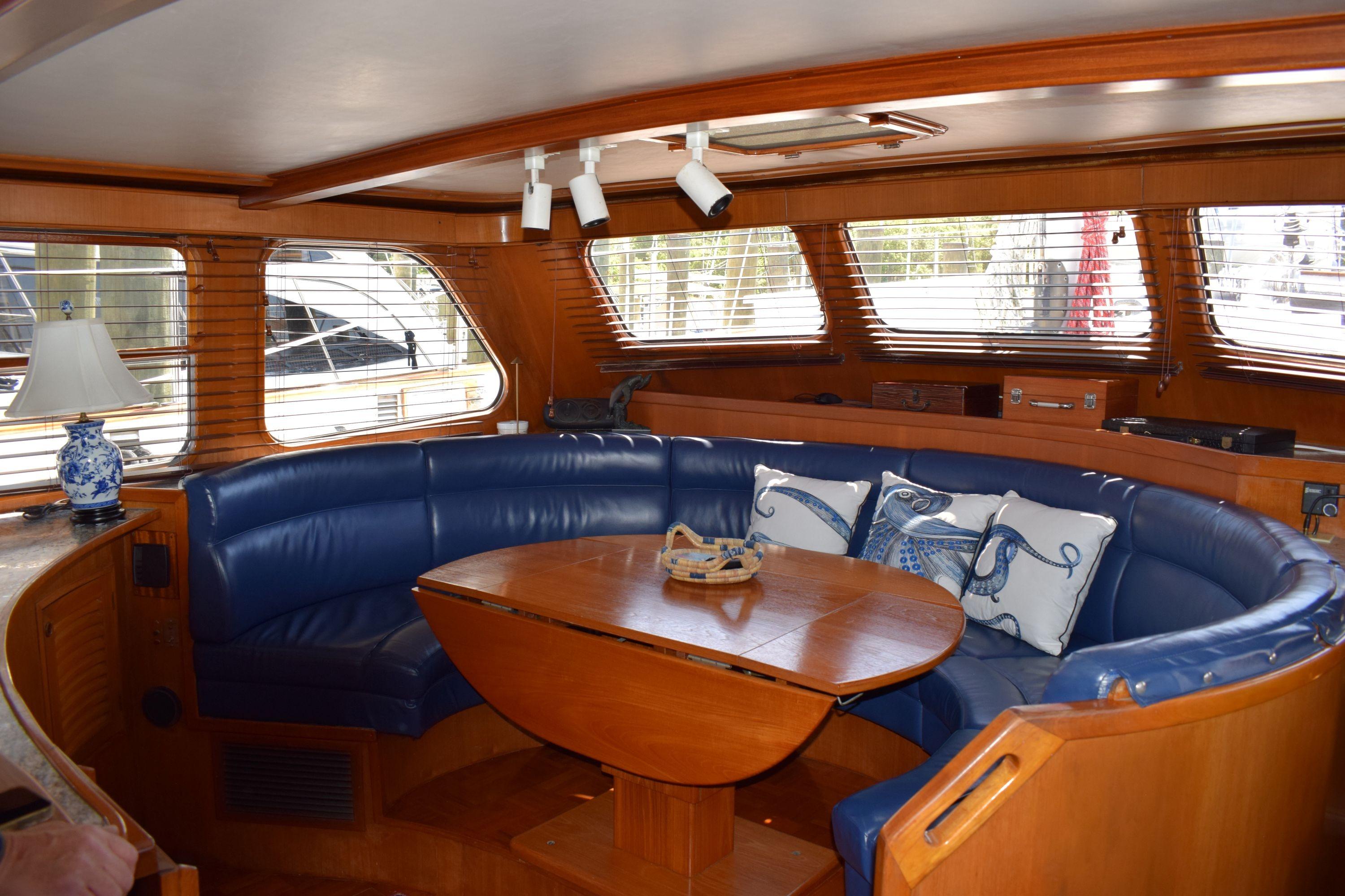 Luxurious interior of 1980 Cheoy Lee 52 Motorsailer with blue leather seating and wooden table.