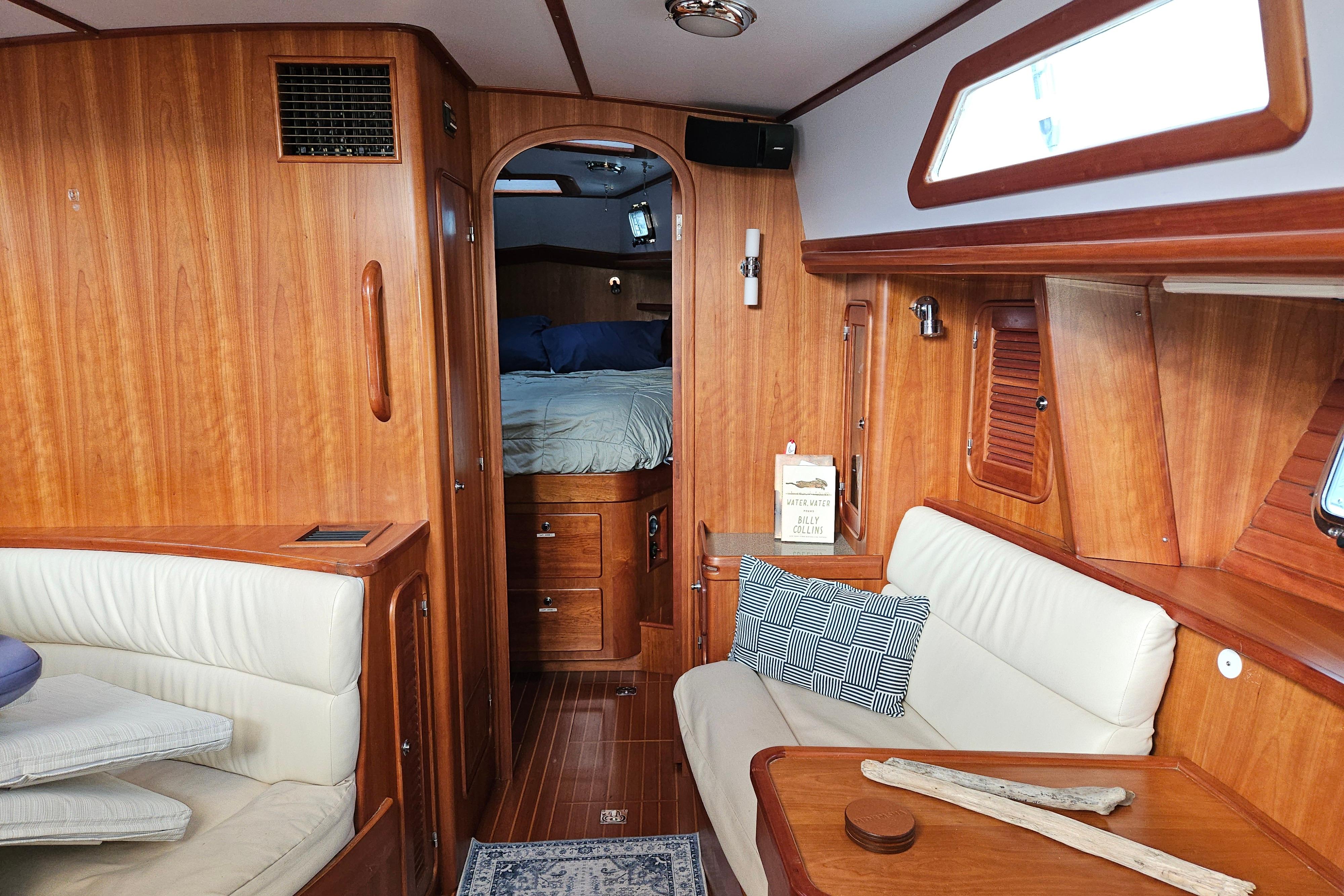 Interior of 2013 Passport 470 Center Cockpit yacht with wood paneling and cozy seating area.