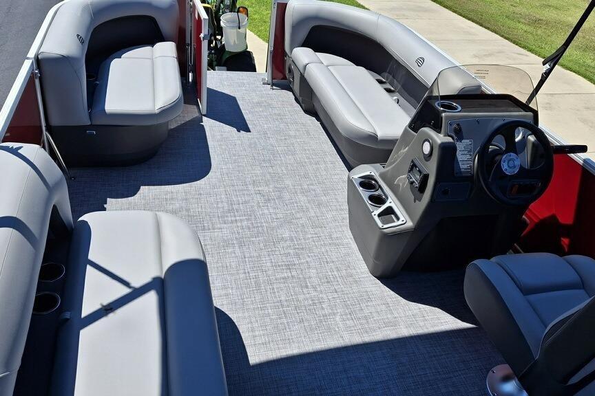 2026 Sun Tracker Party Barge 16 DLX interior with gray seating and steering console.