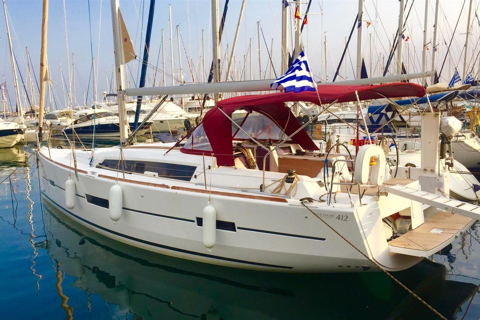 2016 Dufour 412 Grand Large sailboat docked in marina with red canopy and Greek flag.