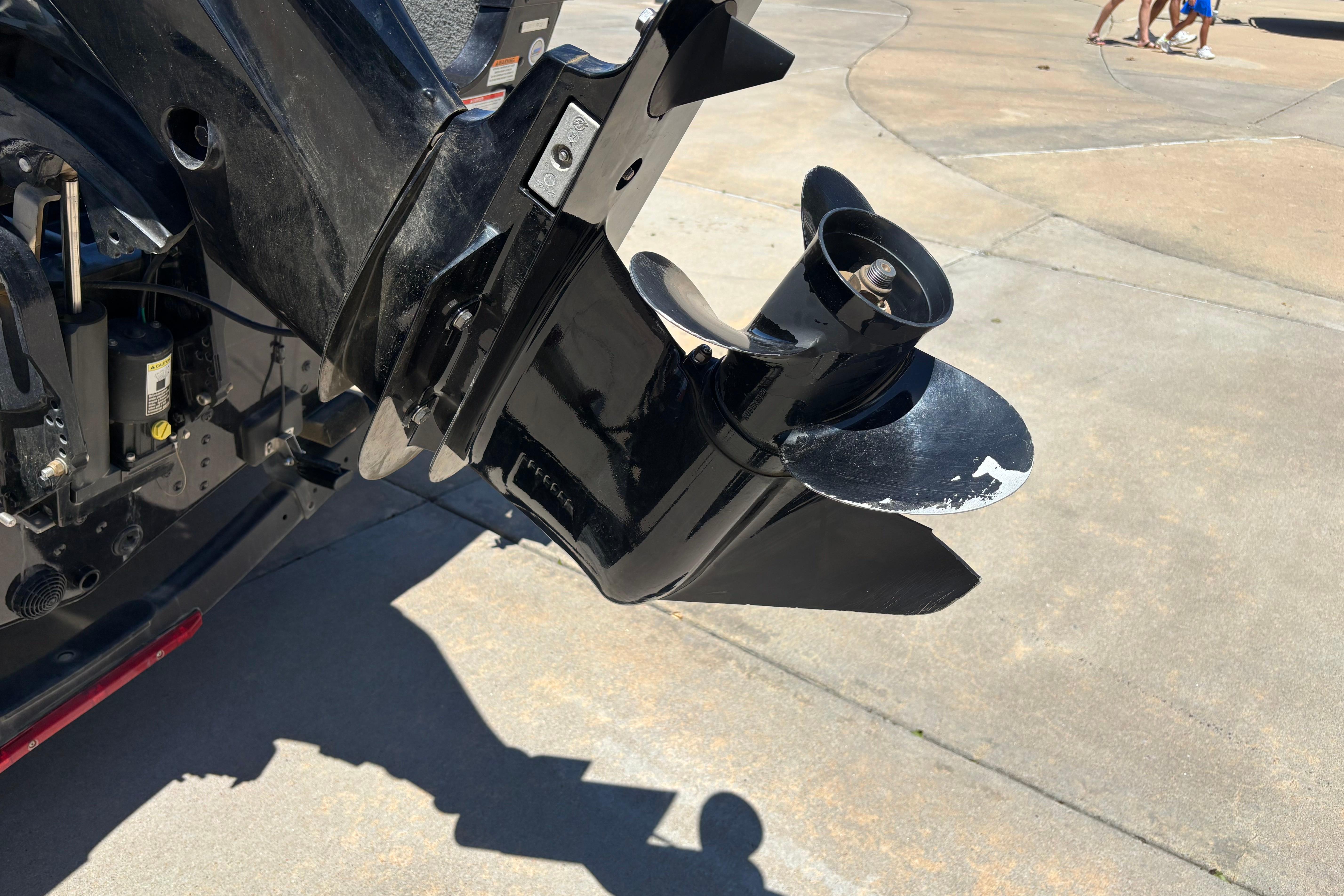 Close-up of a 2021 Alumacraft Classic 165 boat motor propeller on concrete surface.