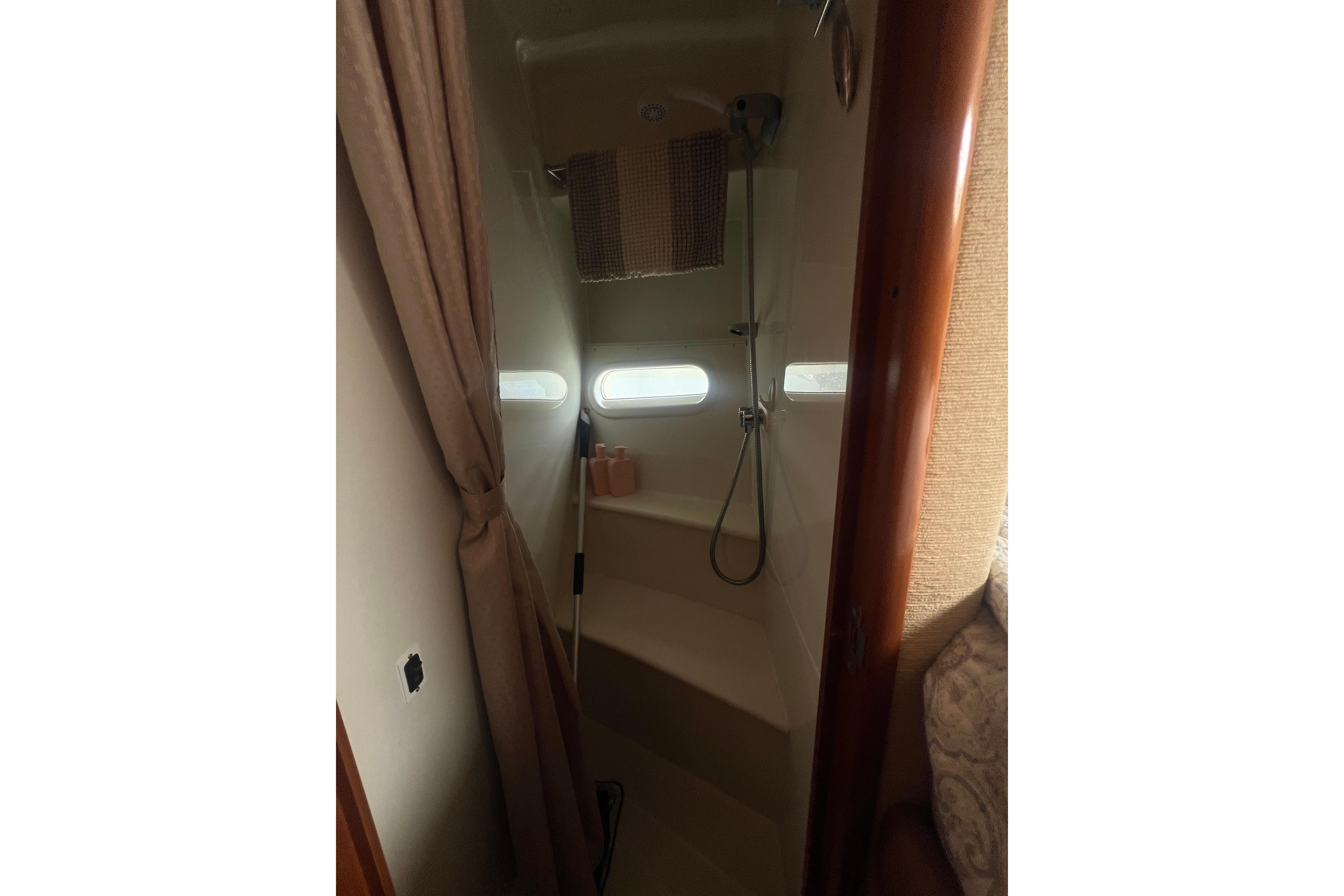 Interior shower area of a 2006 Carver 43 Motor Yacht with curtain and portholes.