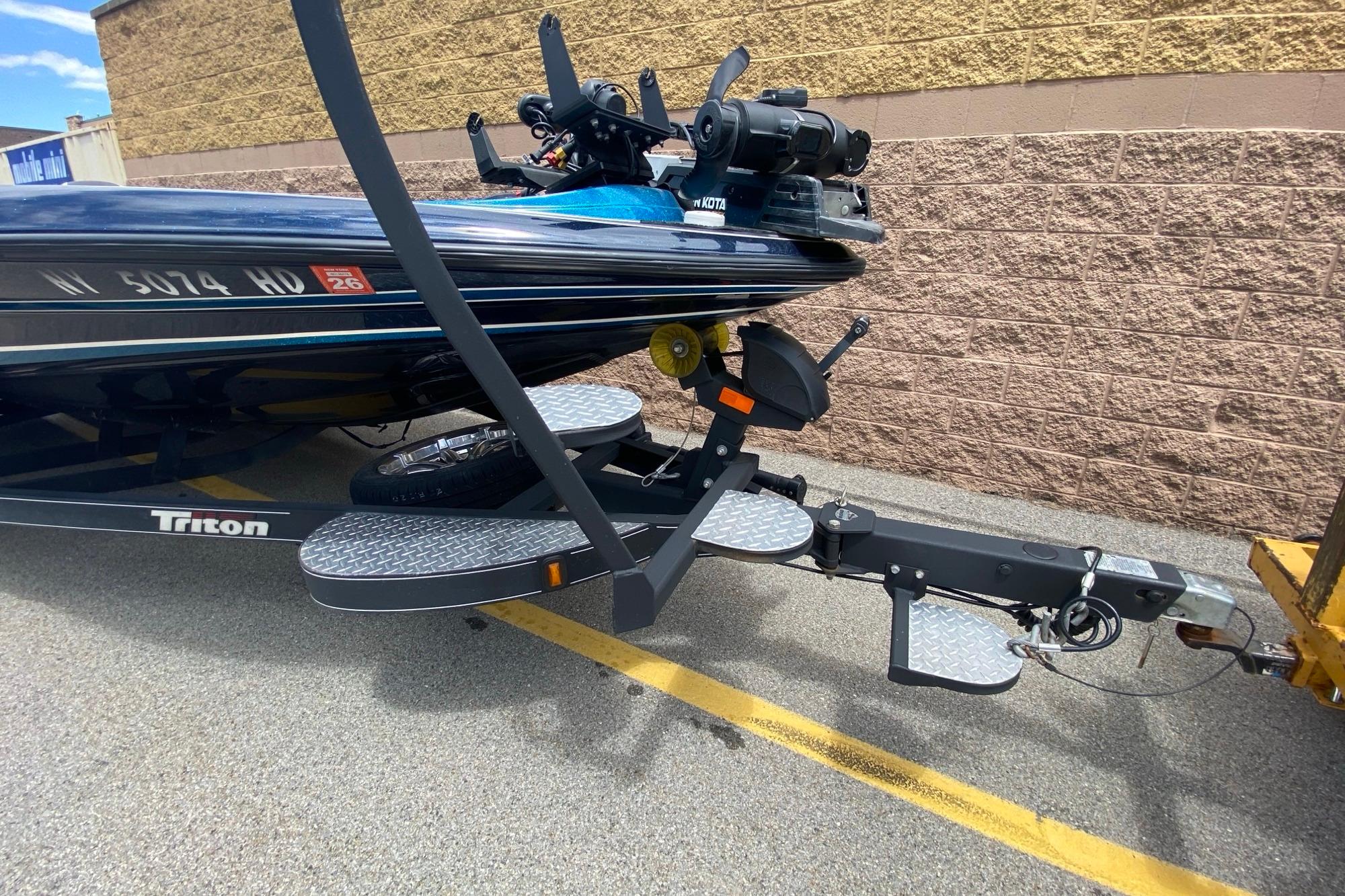 2020 Triton 20 TrX Patriot boat on trailer, parked near brick wall.
