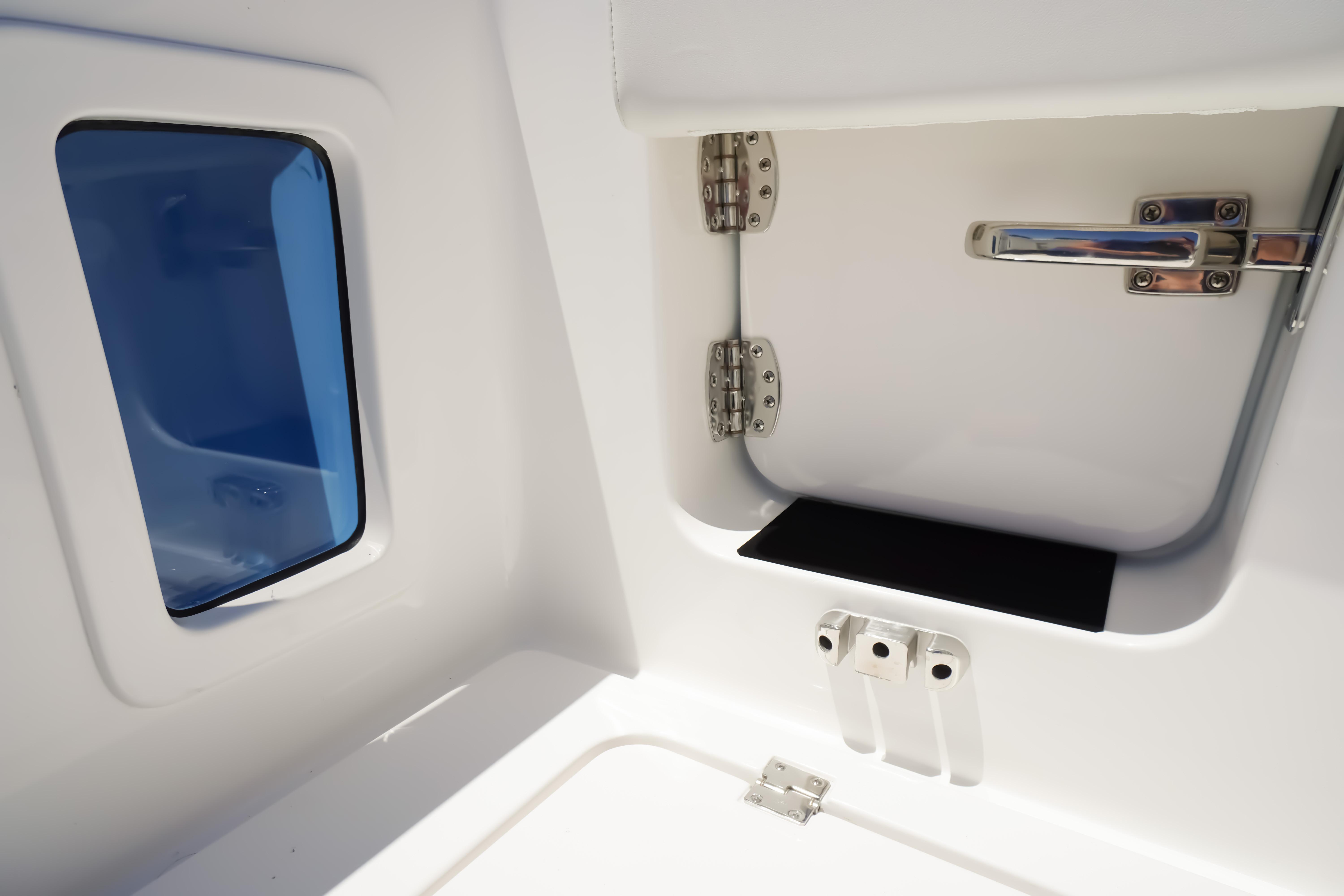 2026 Tidewater 302 CC Adventure boat interior, featuring a storage compartment and window.