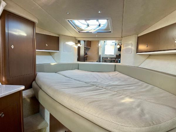 Interior cabin of 2014 Sea Ray 330 Sundancer with skylight and cozy bed.